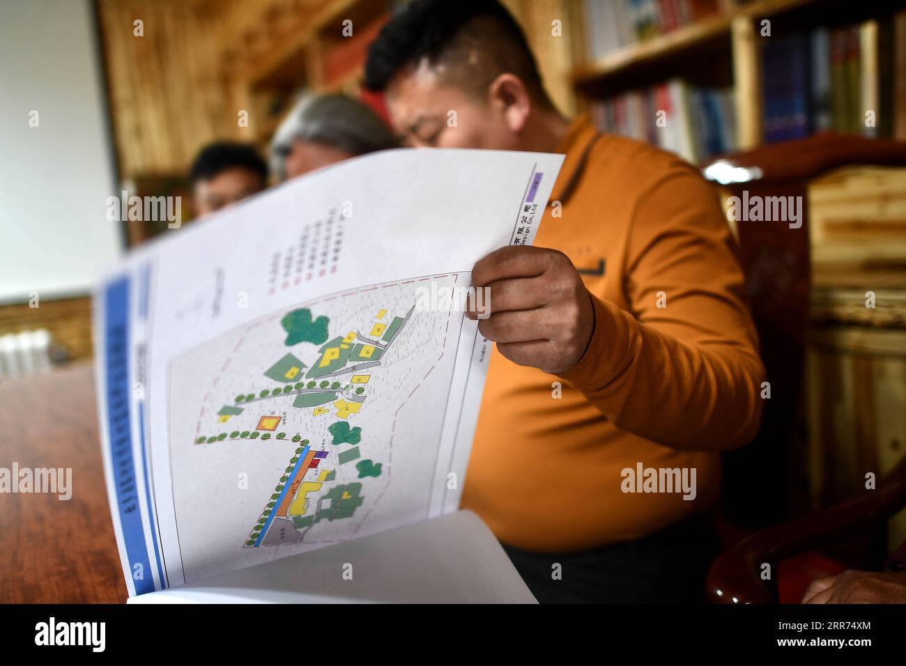 210312 -- YUSHU, 12. März 2021 -- Nyima diskutiert mit seinen Kollegen bei einem Architekturschutzverein in der tibetischen Autonomen Präfektur Yushu, nordwestchinesische Provinz Qinghai, 10. März 2021. Nyima, 40 Jahre alt, wurde in einer Hirtenfamilie im Chindu County in Yushu geboren. Sein Vater ist vor Ort als Handwerker in traditioneller tibetischer Architektur bekannt. Unter dem Einfluss seines Vaters zeigte Nyima seit seiner Kindheit großes Interesse an traditioneller tibetischer Architektur. Im Jahr 2010 erschütterte ein heftiges Erdbeben Yushu und beschädigte viele traditionelle tibetische Gebäude, was Nyima zu der Erkenntnis brachte, dass das u existiert Stockfoto