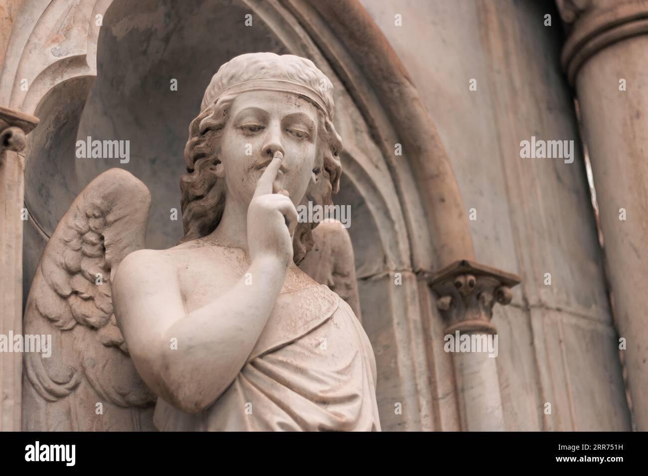 Religiöse Statue eines Engels, der auf einem Friedhof im Freien schweigt Stockfoto