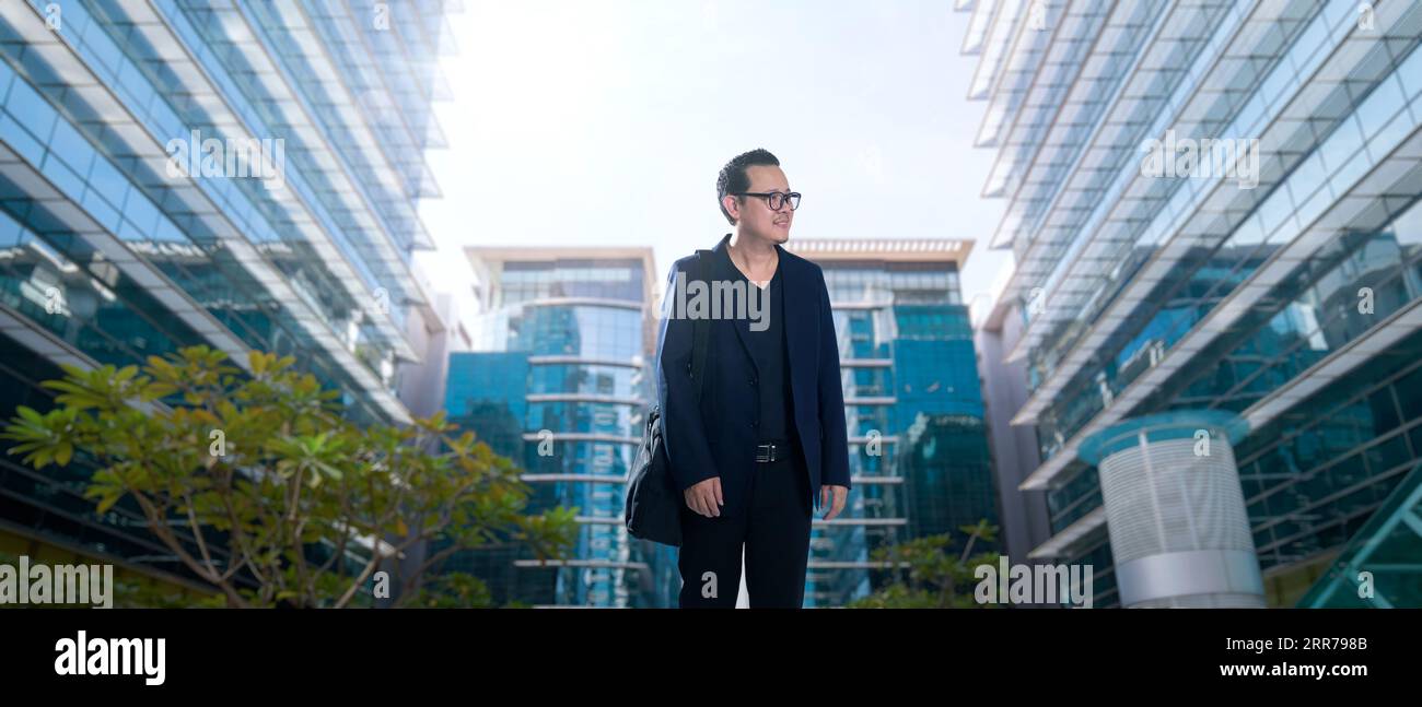 Junger Geschäftsmann, der gerne im Business Center spazieren geht Stockfoto