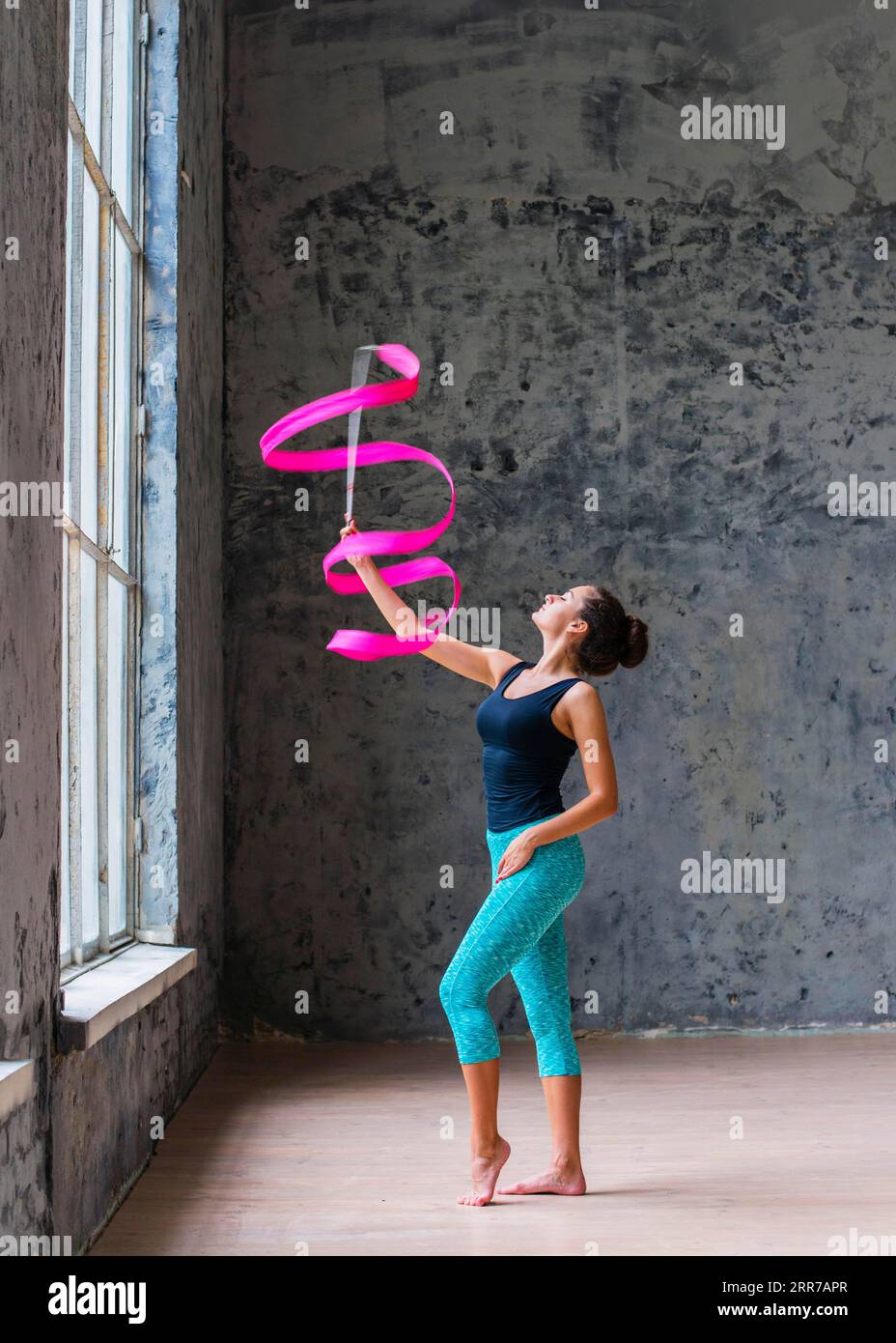Schöne Turnerin tanzt mit rosafarbenem Band Stockfoto