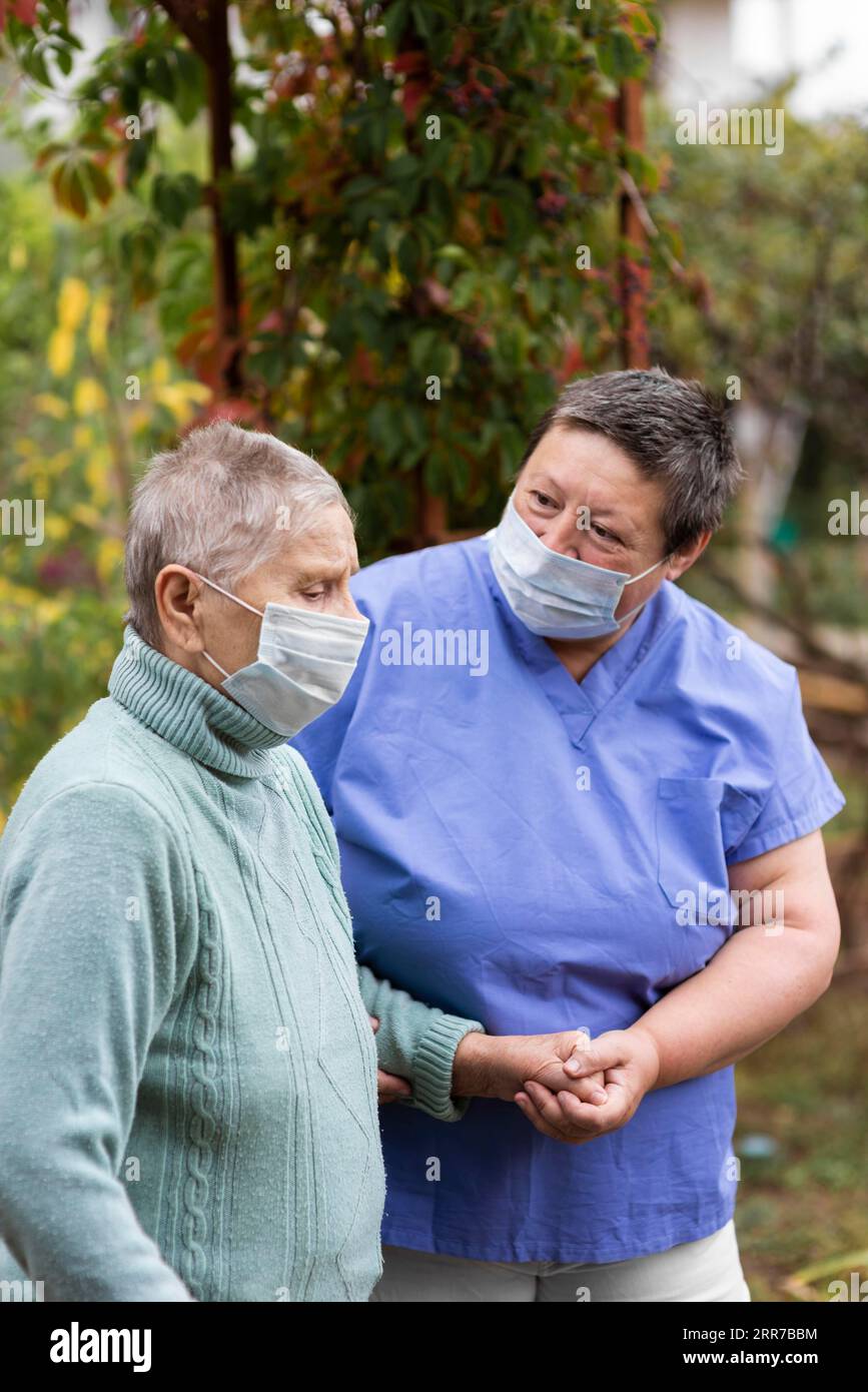 Ältere Frau, die von der Krankenschwester betreut wird Stockfoto