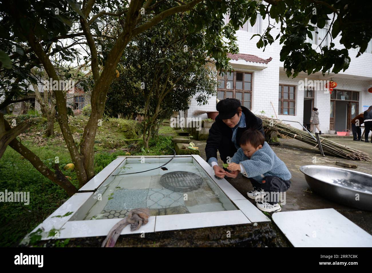 210325 -- ZHANGJIAJIE, 25. März 2021 -- Zhuo Yihang spielt mit seinem Sohn zu Hause im Cili County, Provinz Hunan, im Zentrum Chinas, 20. März 2021. Zhuo Yihang, 33, wurde im Cili County in der Provinz Hunan geboren. Derzeit betreibt er einen Friseurladen in Cili. Eines Tages im Mai 2020 sah Zhuo Yihang zwei alte Menschen, die sich am Straßenrand die Haare schnitten, sogar einer von ihnen blind, und so trat er voran und half. Er teilte diese Erfahrungen in den sozialen Medien und erhielt viele ermutigende Botschaften, weshalb er beschloss, älteren Menschen kostenlose Haarschnitte zu geben. Er besuchte Cili und andere abgelegene Dörfer in den umliegenden Grafschaften Stockfoto