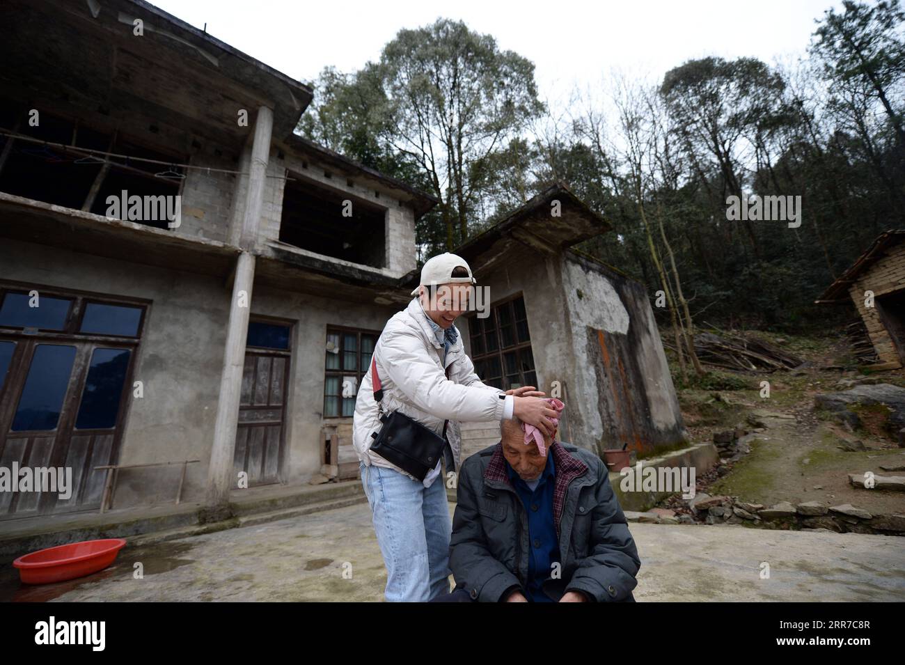 210325 -- ZHANGJIAJIE, 25. März 2021 -- Zhuo Yihang bereitet sich darauf vor, einem älteren Menschen im Dorf Liangshan im Cili County, Provinz Hunan, am 3. März 2021 einen Haarschnitt zu geben. Zhuo Yihang, 33, wurde im Cili County in der Provinz Hunan geboren. Derzeit betreibt er einen Friseurladen in Cili. Eines Tages im Mai 2020 sah Zhuo Yihang zwei alte Menschen, die sich am Straßenrand die Haare schnitten, sogar einer von ihnen blind, und so trat er voran und half. Er teilte diese Erfahrungen in den sozialen Medien und erhielt viele ermutigende Botschaften, weshalb er beschloss, älteren Menschen kostenlose Haarschnitte zu geben. Er ging zu Cili und anderen Re Stockfoto