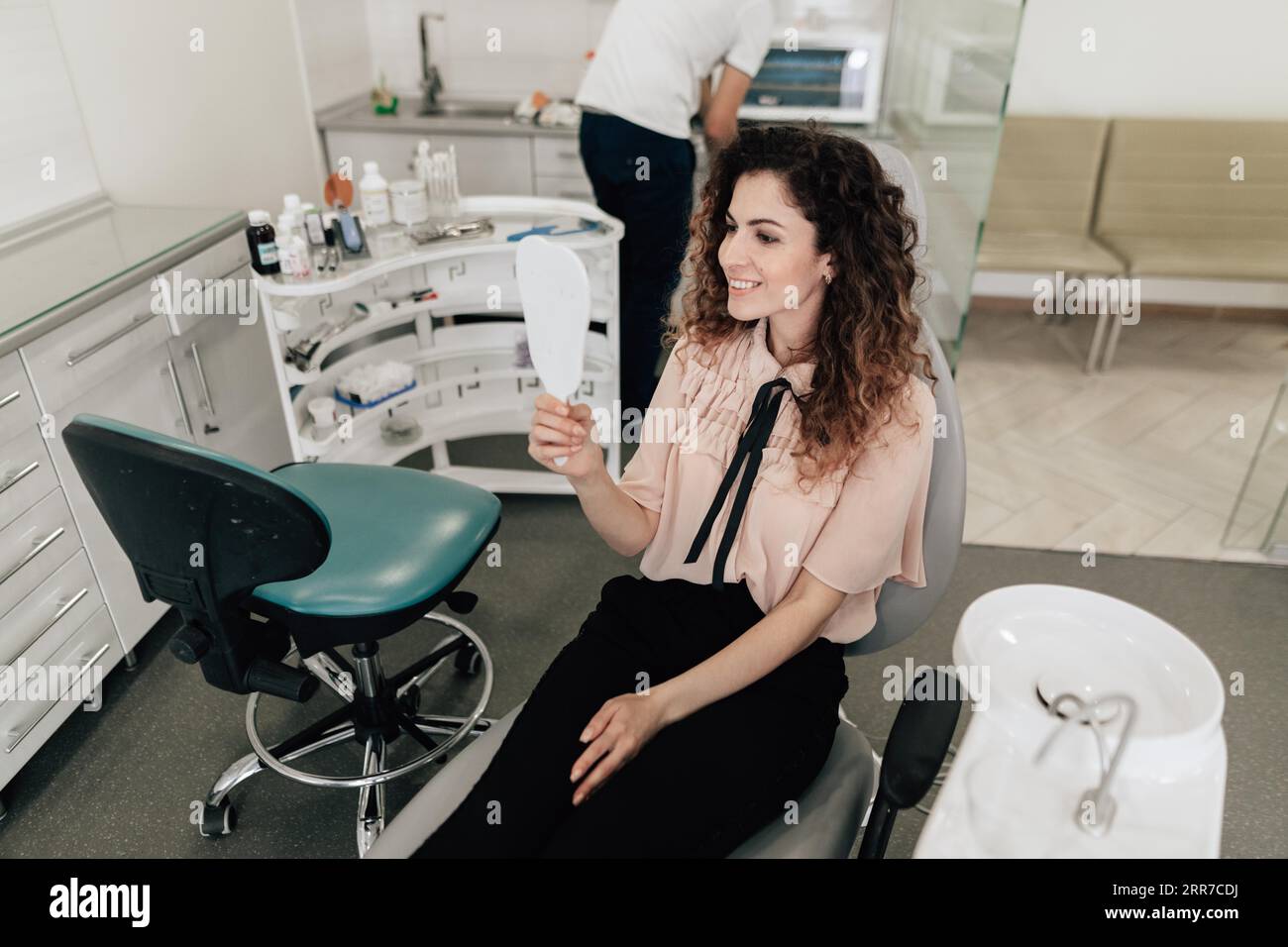 Frau, die die Zähne spiegelt, Zahnarzt-Termin Stockfoto