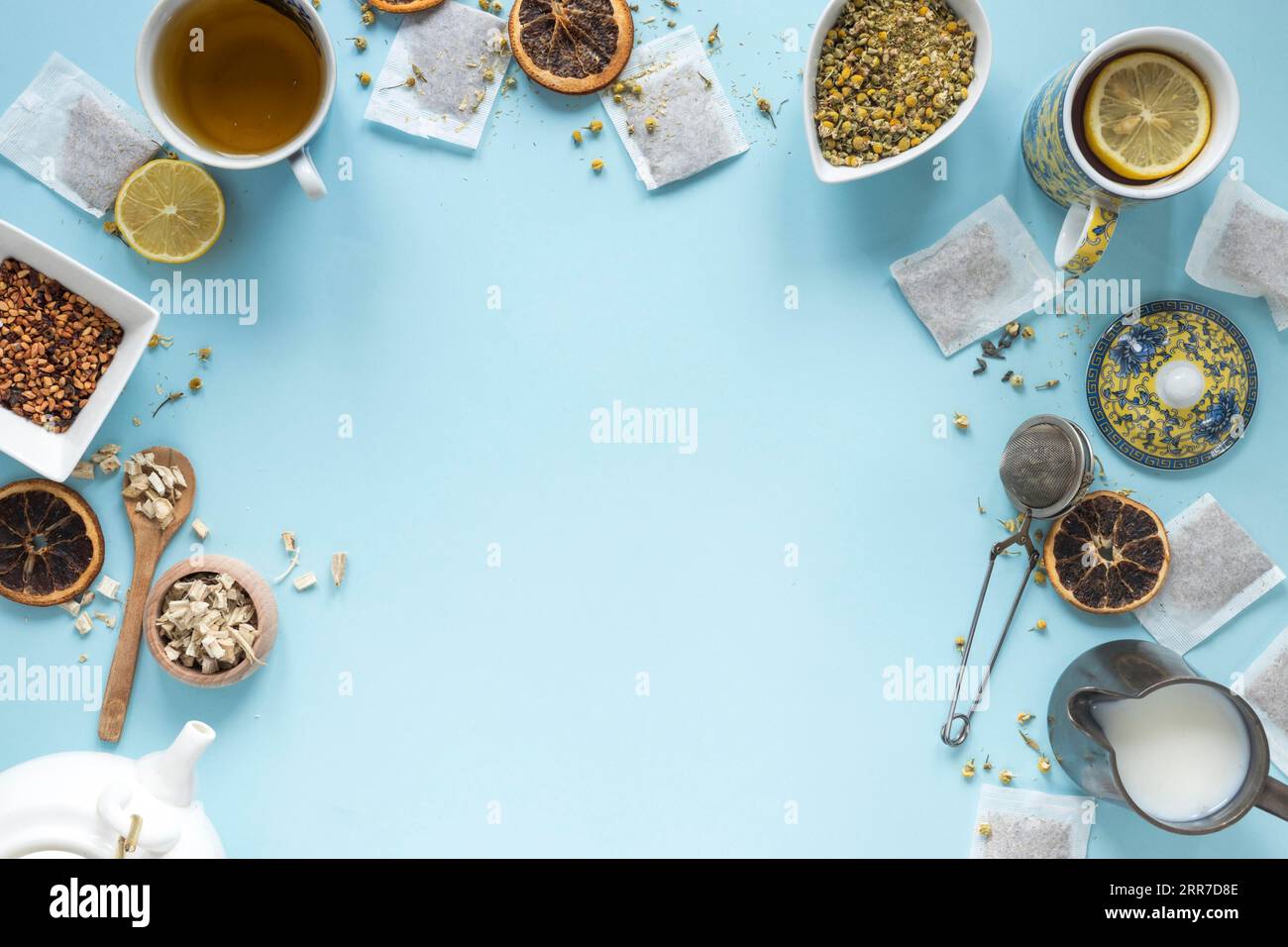 Erhöhte Ansicht Zitronentee Kräuter Milchsieb getrocknete chinesische Chrysantheme Blumen Teekanne Teebeutel angeordnet blauen Hintergrund Stockfoto