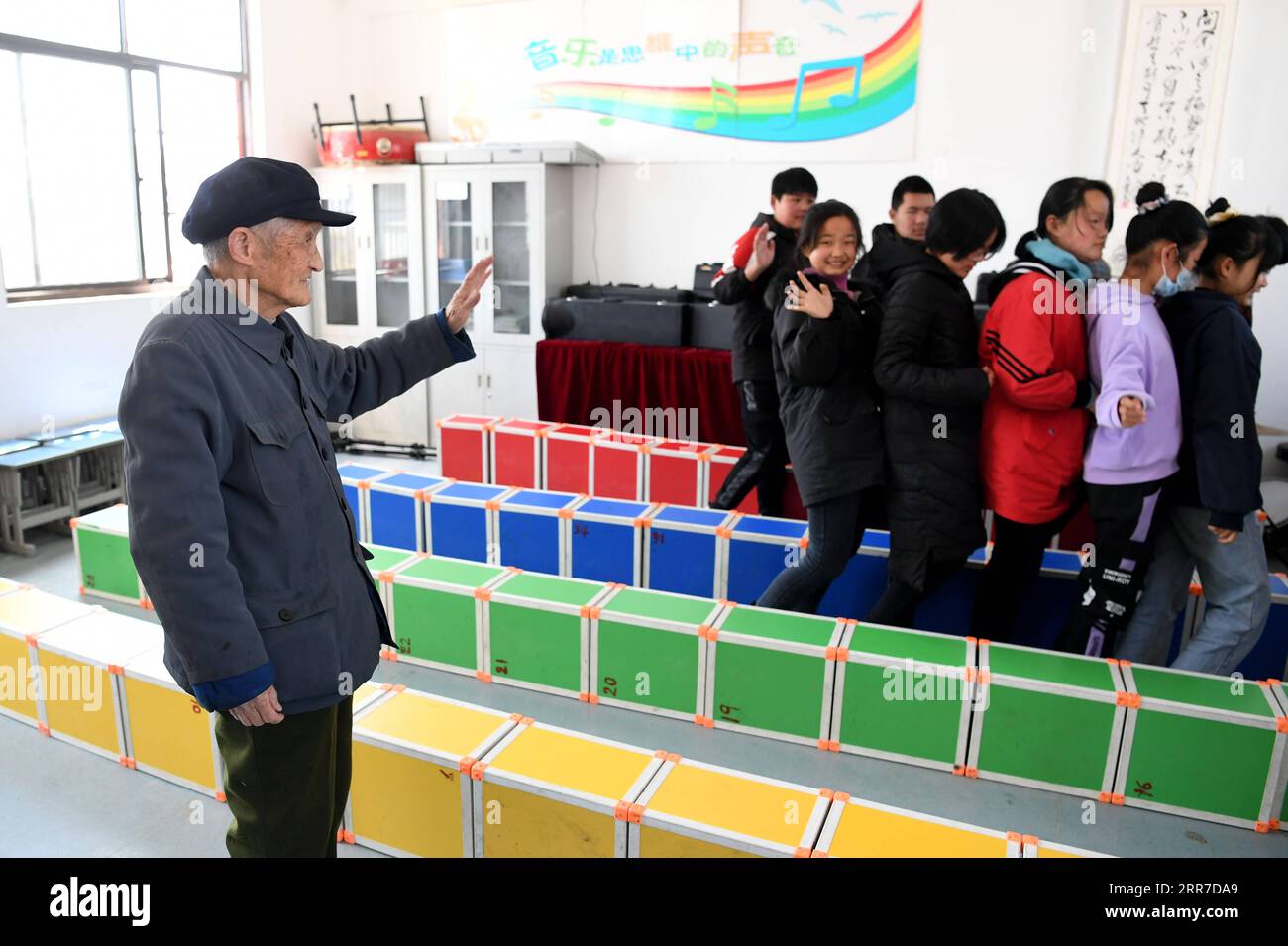 210326 -- HEFEI, 26. März 2021 -- Yan Mingyou verabschiedet sich von den Schülern nach einem Musikunterricht an der Zhuwan Primary School in der Zhuwan Township im Dingyuan County, Chuzhou City, ostchinesische Provinz Anhui, 23. März 2021. Yan Mingyou, 92, ist immer noch als Lehrer für Musik an ländlichen Grundschulen tätig. Als Yan 1990 als Landlehrer in den Ruhestand ging, hat er sich freiwillig engagiert, um Schülern in ländlichen Schulen Musik zu vermitteln. Im Jahr 1953 verließ Yan die Armee und kehrte in seine Heimatstadt Zhuwan Township im Dingyuan County zurück. Er gab einen besseren Job bei der lokalen Regierung auf und entschied sich, in ländlichen Schulen zu arbeiten, um vario zu unterrichten Stockfoto