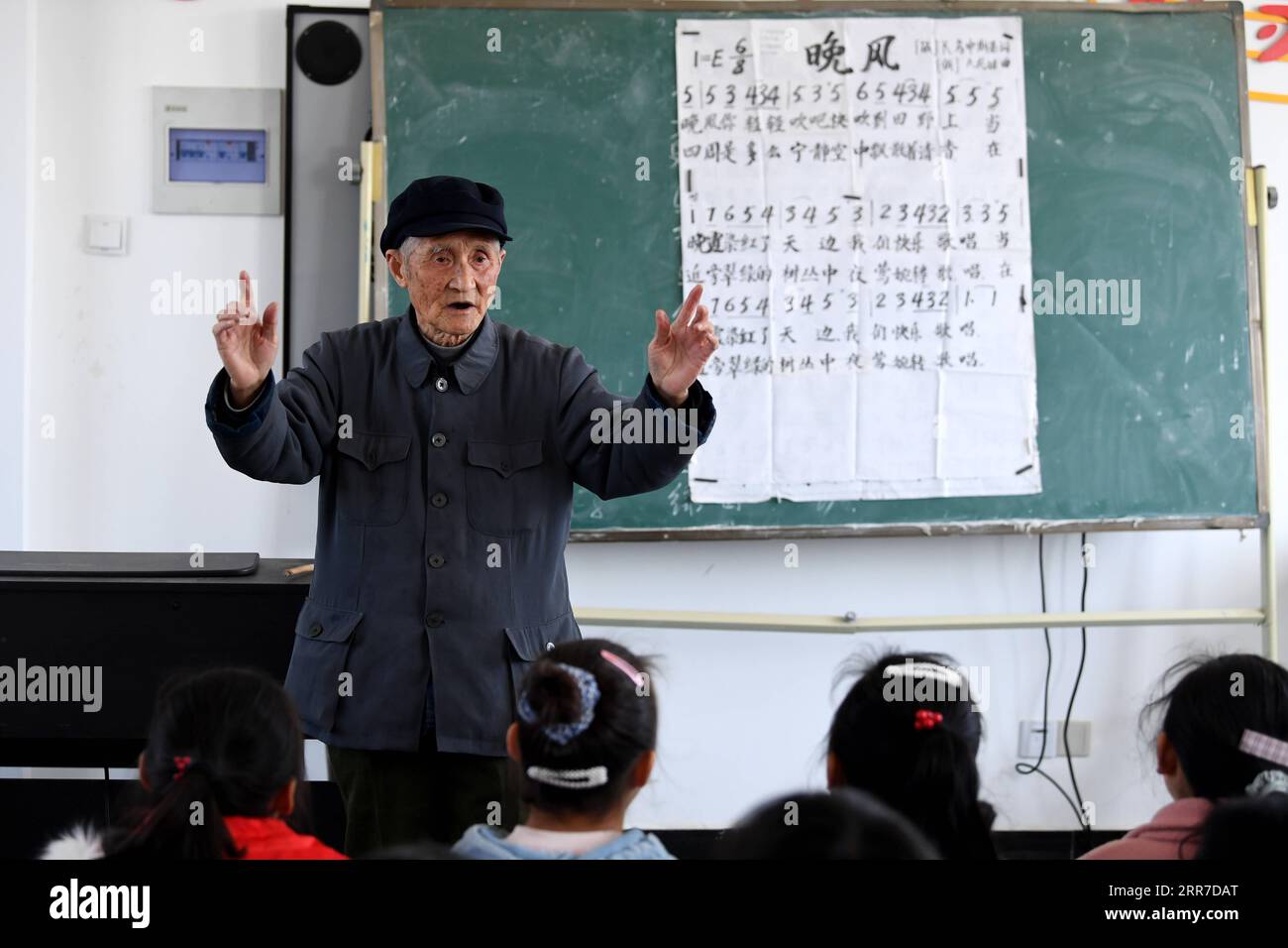 210326 -- HEFEI, 26. März 2021 -- Yan Mingyou unterrichtet Schüler an der Zhuwan Primary School in Zhuwan Township im Dingyuan County, Chuzhou City, ostchinesische Provinz Anhui, 23. März 2021. Yan Mingyou, 92, ist immer noch als Lehrer für Musik an ländlichen Grundschulen tätig. Als Yan 1990 als Landlehrer in den Ruhestand ging, hat er sich freiwillig engagiert, um Schülern in ländlichen Schulen Musik zu vermitteln. Im Jahr 1953 verließ Yan die Armee und kehrte in seine Heimatstadt Zhuwan Township im Dingyuan County zurück. Er gab einen besseren Job bei der lokalen Regierung auf und entschied sich, in ländlichen Schulen zu arbeiten, wo er verschiedene Fächer wie po unterrichtete Stockfoto