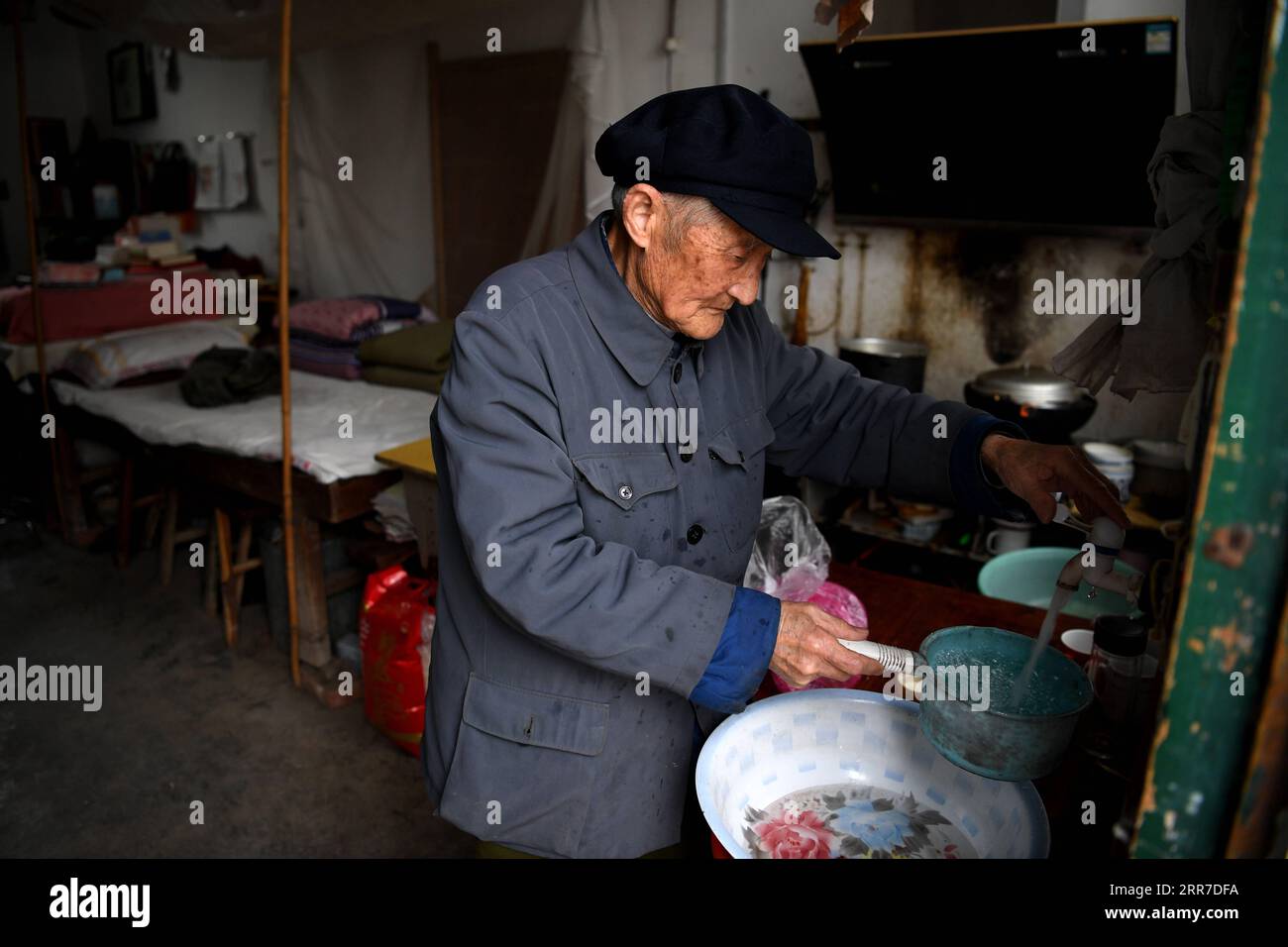 210326 -- HEFEI, 26. März 2021 -- Yan Mingyou bereitet Abendessen in seinem Wohnheim in der Zhuwan Township von Dingyuan County, Chuzhou Stadt, ostchinesische Provinz Anhui, 23. März 2021 vor. Yan Mingyou, 92, ist immer noch als Lehrer für Musik an ländlichen Grundschulen tätig. Als Yan 1990 als Landlehrer in den Ruhestand ging, hat er sich freiwillig engagiert, um Schülern in ländlichen Schulen Musik zu vermitteln. Im Jahr 1953 verließ Yan die Armee und kehrte in seine Heimatstadt Zhuwan Township im Dingyuan County zurück. Er gab einen besseren Job bei der lokalen Regierung auf und entschied sich, in ländlichen Schulen zu arbeiten, wo er verschiedene Fächer wie Politik, Musik und t unterrichtete Stockfoto