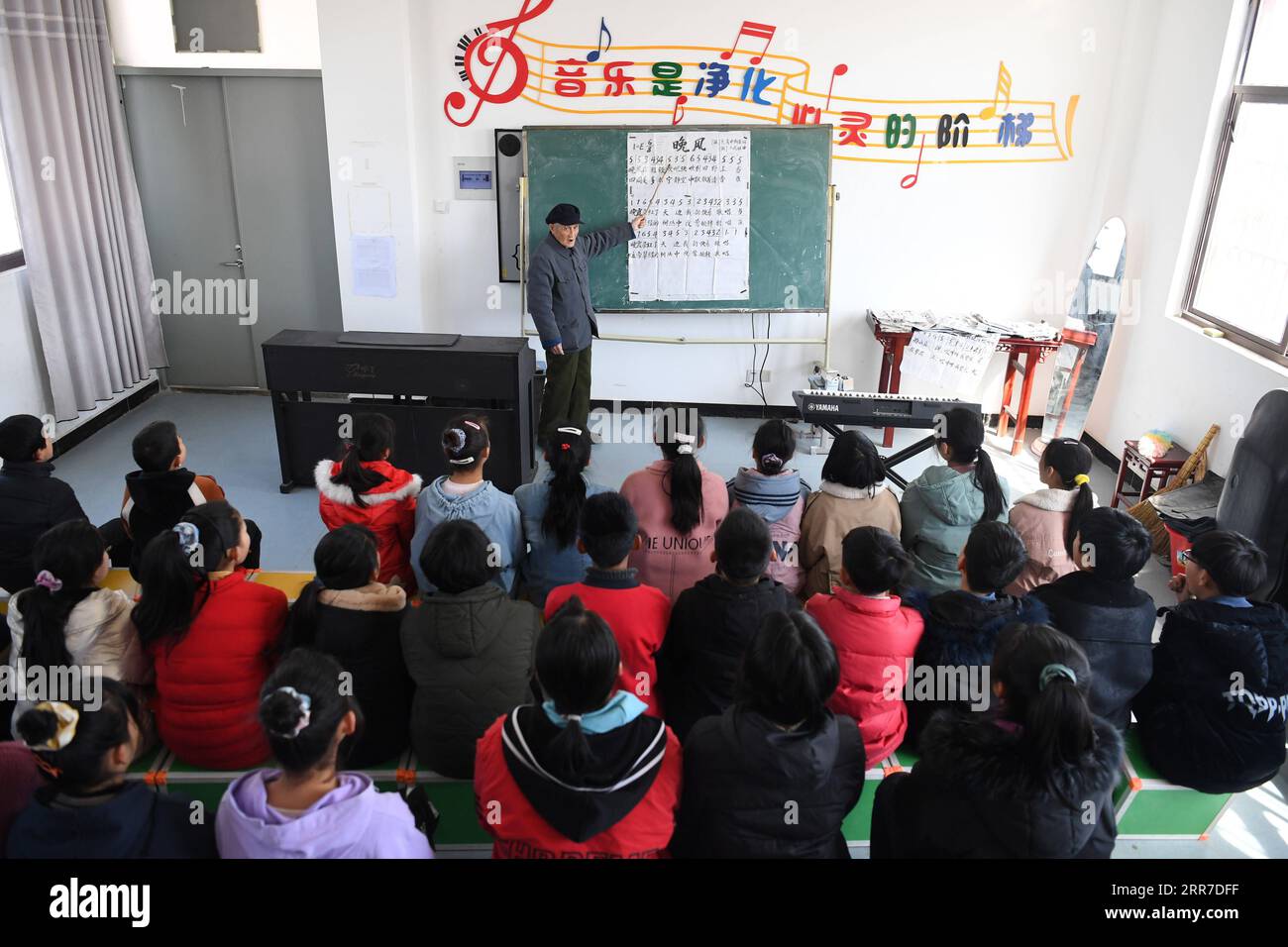 210326 -- HEFEI, 26. März 2021 -- Yan Mingyou lehrt ein Lied für Schüler an der Zhuwan Primary School in Zhuwan Township von Dingyuan County, Chuzhou City, ostchinesische Provinz Anhui, 23. März 2021. Yan Mingyou, 92, ist immer noch als Lehrer für Musik an ländlichen Grundschulen tätig. Als Yan 1990 als Landlehrer in den Ruhestand ging, hat er sich freiwillig engagiert, um Schülern in ländlichen Schulen Musik zu vermitteln. Im Jahr 1953 verließ Yan die Armee und kehrte in seine Heimatstadt Zhuwan Township im Dingyuan County zurück. Er gab einen besseren Job bei der lokalen Regierung auf und entschied sich, in ländlichen Schulen zu arbeiten, wo er verschiedene Fächer wie p unterrichtete Stockfoto