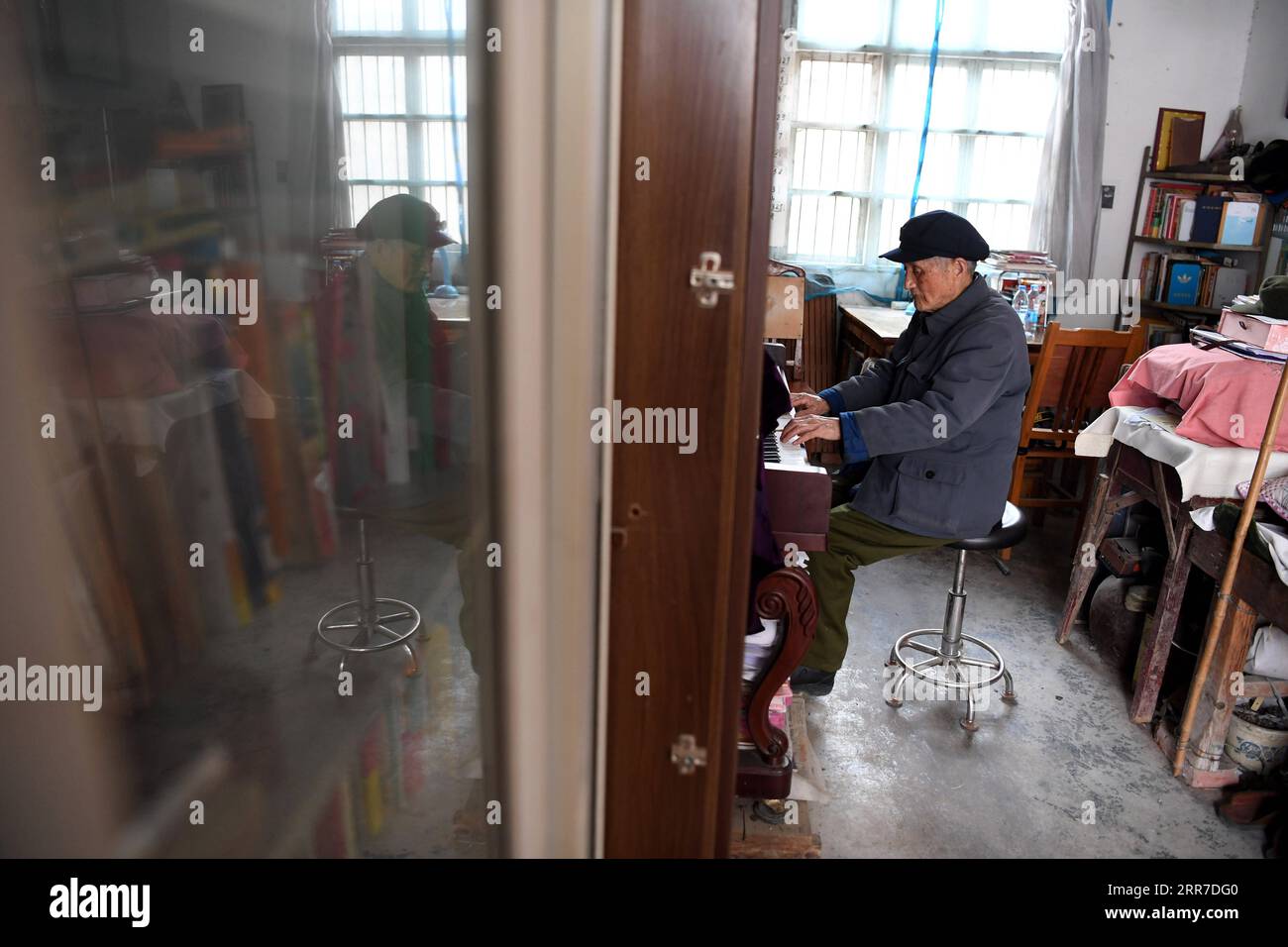 210326 -- HEFEI, 26. März 2021 -- Yan Mingyou spielt Klavier in seinem Wohnheim in Zhuwan Township im Dingyuan County, Chuzhou City, ostchinesische Provinz Anhui, 23. März 2021. Yan Mingyou, 92, ist immer noch als Lehrer für Musik an ländlichen Grundschulen tätig. Als Yan 1990 als Landlehrer in den Ruhestand ging, hat er sich freiwillig engagiert, um Schülern in ländlichen Schulen Musik zu vermitteln. Im Jahr 1953 verließ Yan die Armee und kehrte in seine Heimatstadt Zhuwan Township im Dingyuan County zurück. Er gab einen besseren Job bei der lokalen Regierung auf und entschied sich, in ländlichen Schulen zu arbeiten, wo er verschiedene Fächer wie Politik, Musik und t unterrichtete Stockfoto