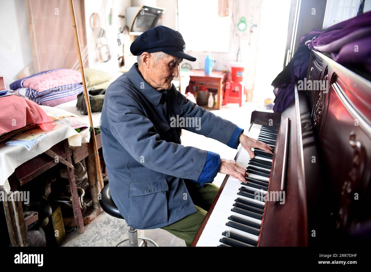 210326 -- HEFEI, 26. März 2021 -- Yan Mingyou spielt Klavier in seinem Wohnheim in Zhuwan Township im Dingyuan County, Chuzhou City, ostchinesische Provinz Anhui, 23. März 2021. Yan Mingyou, 92, ist immer noch als Lehrer für Musik an ländlichen Grundschulen tätig. Als Yan 1990 als Landlehrer in den Ruhestand ging, hat er sich freiwillig engagiert, um Schülern in ländlichen Schulen Musik zu vermitteln. Im Jahr 1953 verließ Yan die Armee und kehrte in seine Heimatstadt Zhuwan Township im Dingyuan County zurück. Er gab einen besseren Job bei der lokalen Regierung auf und entschied sich, in ländlichen Schulen zu arbeiten, wo er verschiedene Fächer wie Politik, Musik und t unterrichtete Stockfoto
