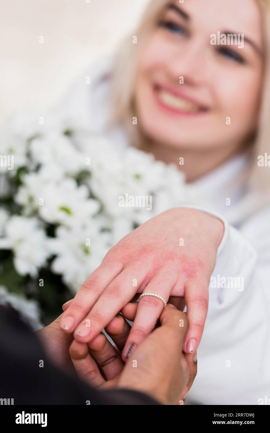 Mann, der seinen Verlobten mit einem Diamant-Verlobungsring anlegt Stockfoto