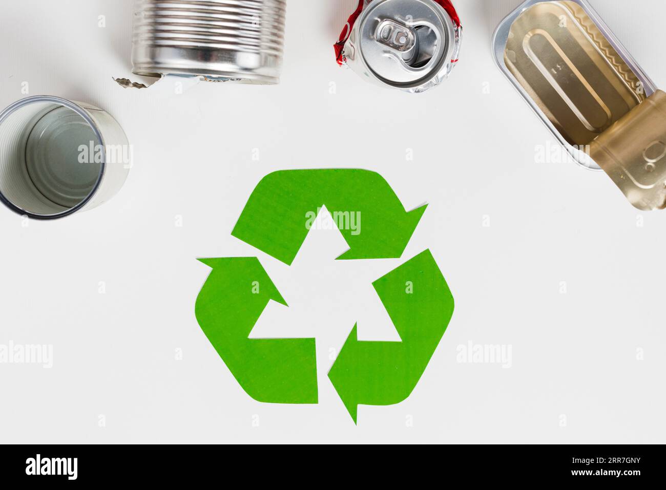 Recycling-Symbol neben gebrauchter Metallverpackung Stockfoto