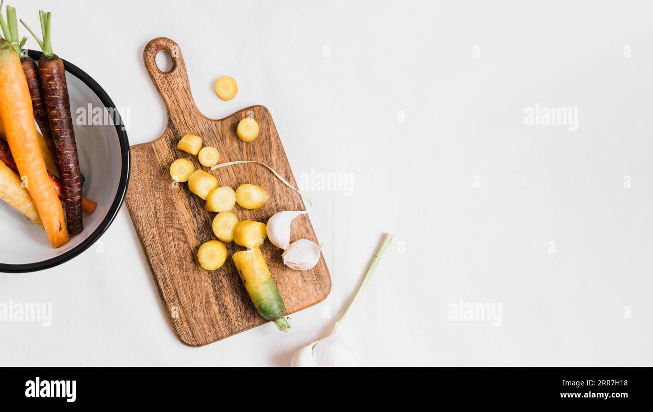 Schneidet Karotte Knoblauchzehen Schneidebrett weißen Hintergrund Stockfoto