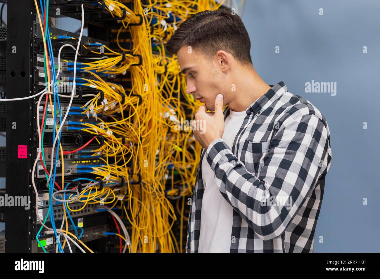 Junger Netzwerktechniker, Serverraum, mittlere Aufnahme Stockfoto