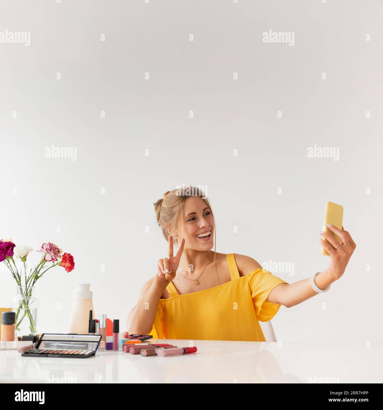 Frau nimmt Selfie, während sie Zeichen des Friedens zeigt Stockfoto