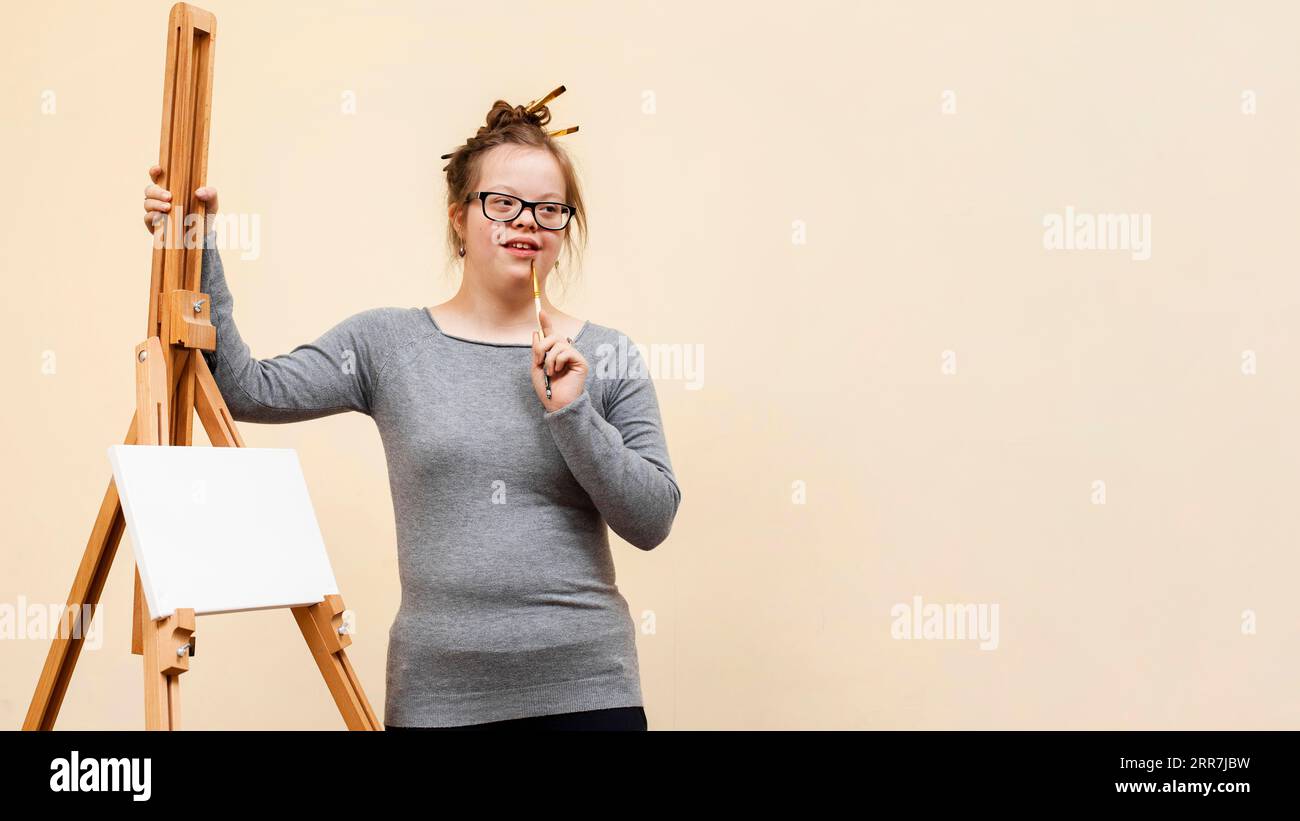 Frontansicht Girl-Down-Syndrom mit Staffelei Stockfoto