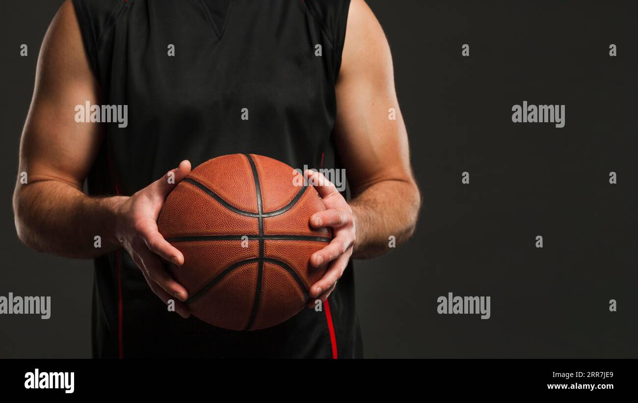 Vorderansicht des Basketballs, der von einem männlichen Spieler gehalten wird, mit Kopierraum Stockfoto