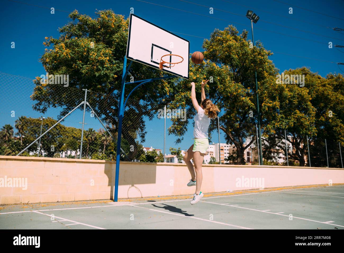 Junge Frau macht Basketballschuss Stockfoto