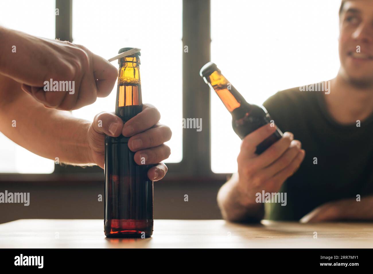 Mann schauende Person, die ein braunes Bierflaschenrestaurant öffnet Stockfoto