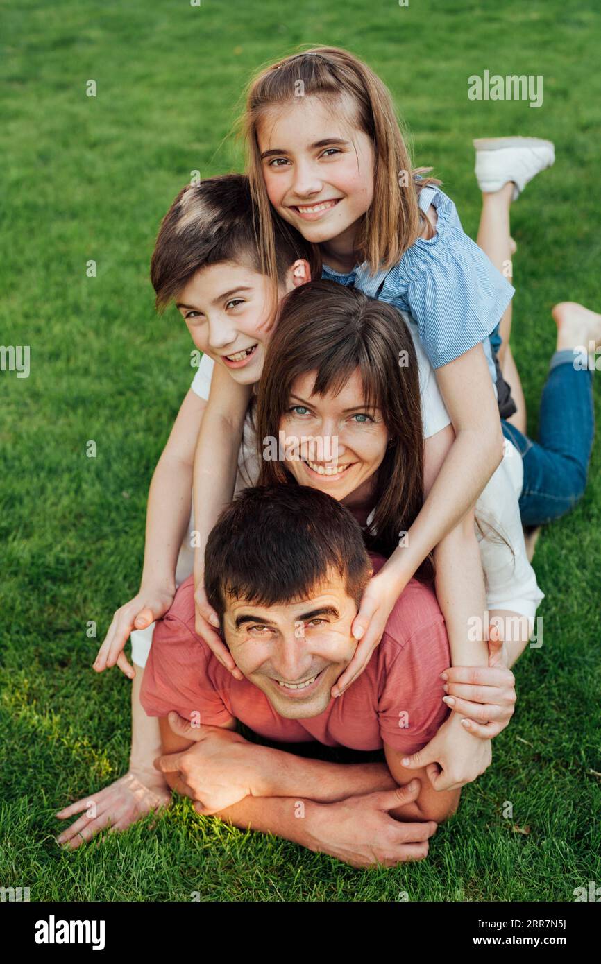 Porträt glückliche Familie, die Graspark legt Stockfoto