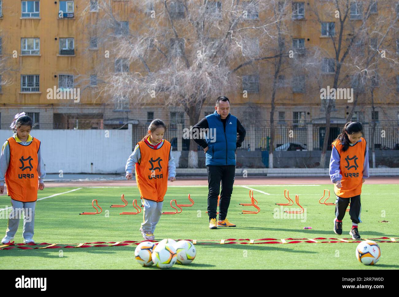 210405 -- SHAWAN, 5. April 2021 -- Xia Songhao 2nd R und seine Schüler nehmen an einer Schulung in Shawan City, Nordwestchinas autonomer Region Xinjiang Uygur, 1. April 2021 Teil. 2011 wurde die Mädchenfußballmannschaft der No. 2 Primary School in Shawan City gegründet. Mit der Leitung von Xia Songhao, der seit fast zehn Jahren Fußball auf dem Campus trainiert, ist das Mädchen-Fußballteam zu einer vielfältigen Gruppe aus multiethnischen Spielern geworden. Nach einem kontinuierlichen und strengen Training hat das Team hervorragende Ergebnisse erzielt und eine Reihe von Meisterschaften auf verschiedenen Ebenen gewonnen. SPCHINA-XINJI Stockfoto