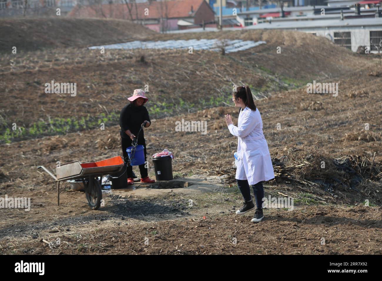 210407 -- SHENYANG, 7. April 2021 -- Sun Yi begrüßt eine Dorfbewohnerin auf dem Weg zu einem Patienten nach Hause im Dorf Qianyang, Donggang Stadt in der nordöstlichen chinesischen Provinz Liaoning, 6. April 2021. Sun Yi, geboren 1997, arbeitet als Dorfarzt im Dorf Qianyang. Nach dem Abschluss des Studiums mit Schwerpunkt klinische Medizin beschloss sie, in ihre Heimatstadt zurückzukehren und die Gesundheit der Einheimischen zu schützen. Das Dorf Qianyang hat eine Bevölkerung von über 000 Menschen, in denen eine ganze Reihe von Menschen an Bluthochdruck und Diabetes leiden. Einige ältere Dorfbewohner werden von ihren Kindern zurückgelassen, die als Wanderarbeiter arbeiten Stockfoto