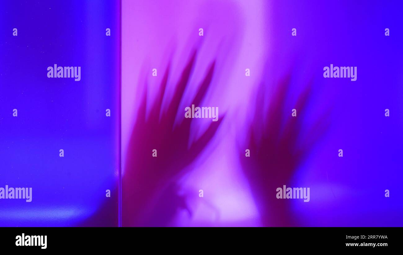 Defokussierte Abstraktion der Silhouette des Arms, Hand-gruselige Action, Alien, Geist, Halloween-Konzept, Spuk und Horror in mehrfarbigem Hintergrund Stockfoto