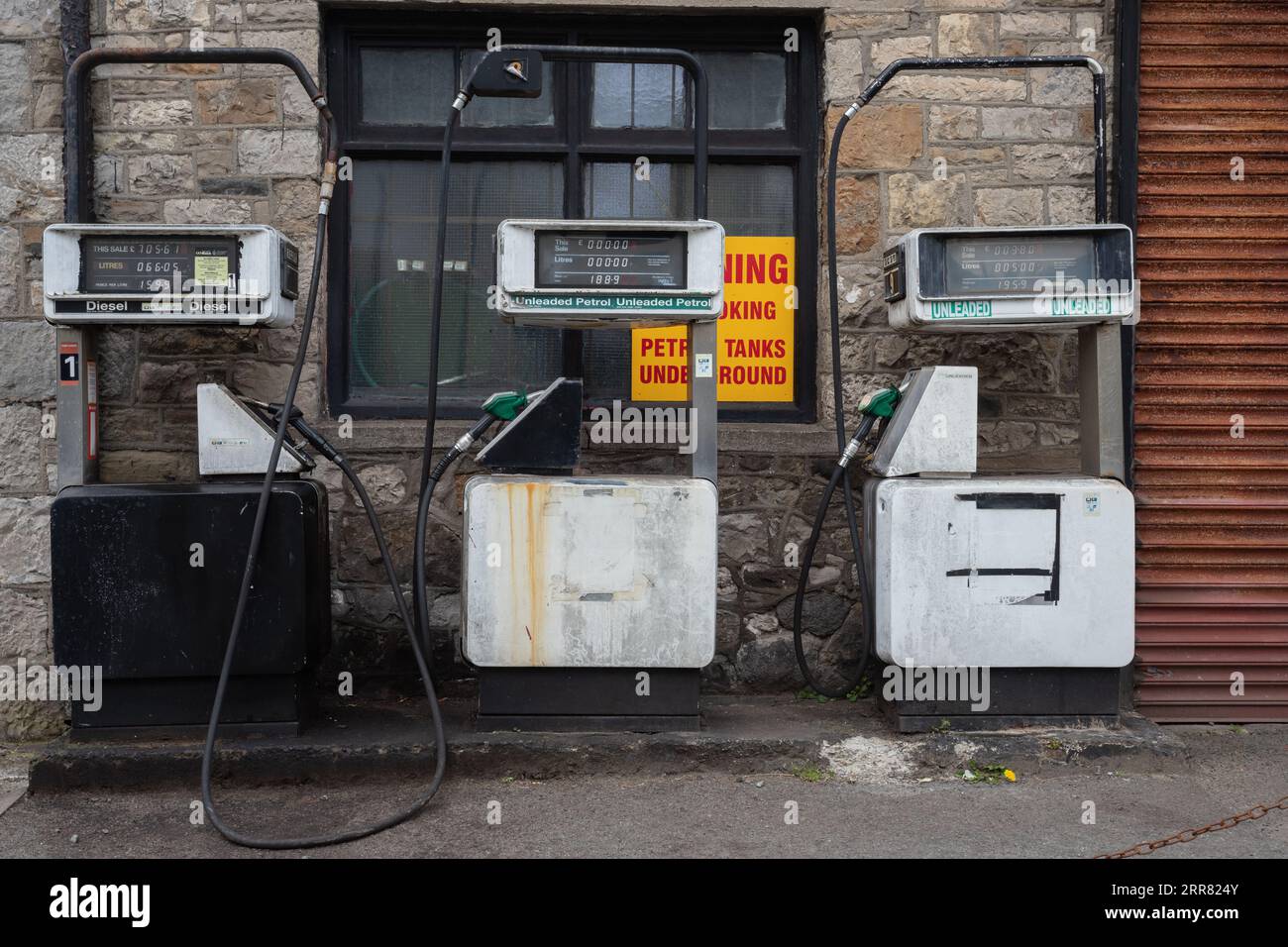 Drei Benzinpumpen mit beleuchteten Nummern, von denen eine Glühlampe fehlt Stockfoto