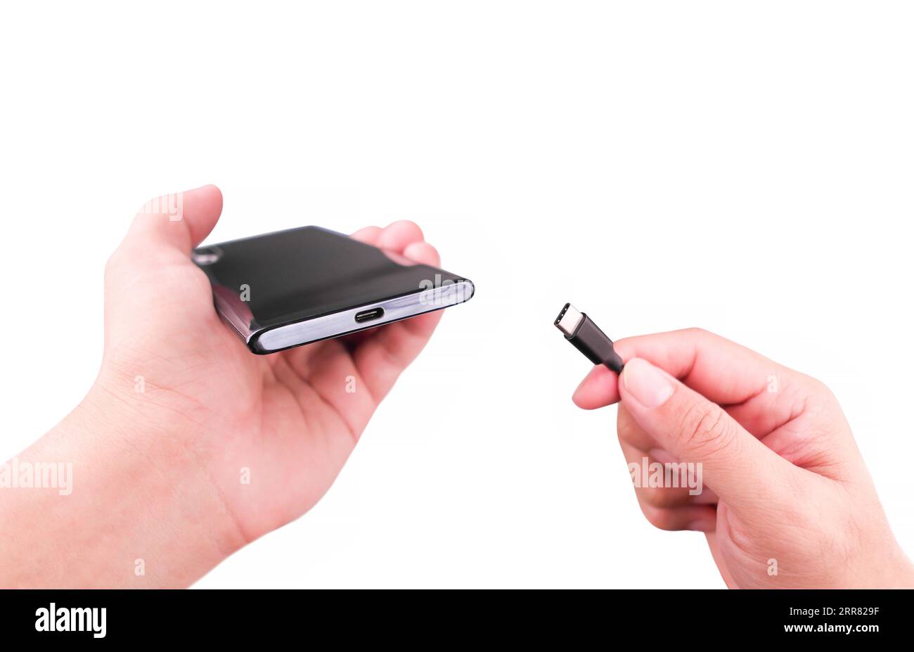 Führen Sie das Ladekabel von Hand in den Typ-C-Anschluss eines Smartphones ein. Laden Sie Ihr Telefon über ein Hochgeschwindigkeits-Ladekabel und ein USB-Anschluss-Ladegerät vom Typ C auf Stockfoto