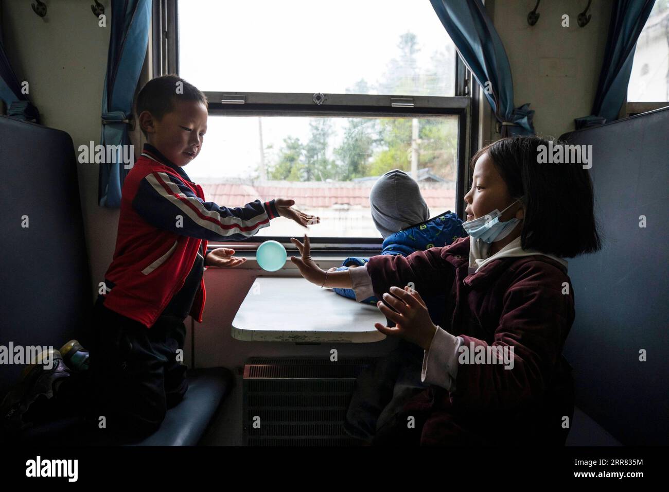210415 -- XICHANG, 15. April 2021 -- Kinder fahren mit dem Zug 5633 zur Schule in der südwestchinesischen Provinz Sichuan, 11. April 2021. Während moderne Hochgeschwindigkeitszüge an neuen Bahnhöfen in ganz China vorbeifahren, verkehren noch immer ein Paar langsame Züge durch das Daliang-Gebirge. Die 5633/5634 Züge verkehren zwischen Puxiong und Panzhihua in der Provinz Sichuan mit einer durchschnittlichen Geschwindigkeit von weniger als 40 km/h. Die Fahrt mit 26 Stationen dauert zwischen elf Stunden und vier Minuten, wobei die Ticketpreise zwischen 2 Yuan und 25,5 Yuan etwa 0,3 bis 3,9 US-Dollar betragen. Die langsam fahrenden Züge schicken die Kinder zur Schule Stockfoto