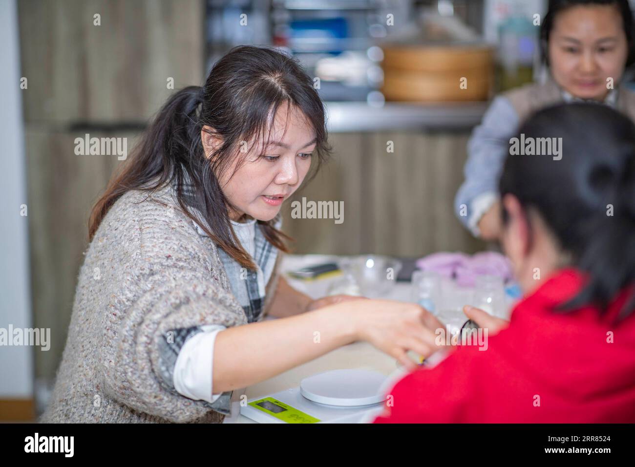 210418 -- CHONGQING, 18. April 2021 -- Ouyang Qinyun L lehrt Auszubildende in ihrem Atelier im Bezirk Yubei der südwestchinesischen Gemeinde Chongqing, 26. März 2021. Ein Bekleidungsdesigner, der in Chongqing zum Koch wurde, hat eine atemberaubende Chemie zwischen Kunst und gedämpftem Brötchen geschaffen. Ouyang Qinyun, 40, ist ein berühmter chinesischer Social-Media-Koch, der sich auf gedämpftes Brötchen oder Mantou auf Chinesisch spezialisiert hat. Mantou wird normalerweise aus Allzweckmehl, Hefe und Wasser hergestellt und ist ein Grundnahrungsmittel in China, insbesondere im Norden. Ich habe gelernt, dass gedämpfte Brötchen in verschiedene Formen verwandelt werden können. Das ist wirklich inspirierend Stockfoto