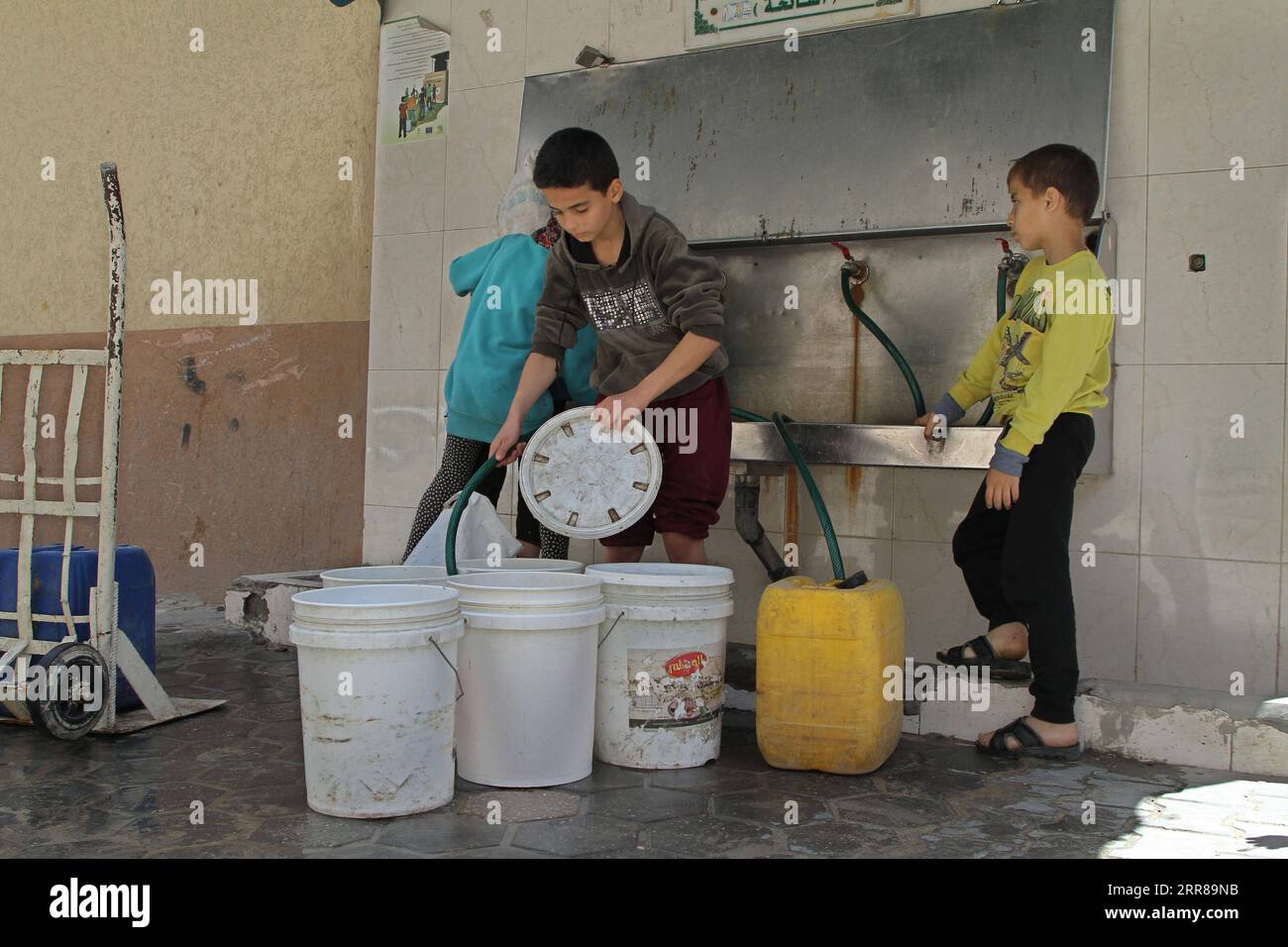 210426 -- GAZA, 26. April 2021 -- palästinensische Kinder füllen am 22. April 2021 im Flüchtlingslager Shati in Gaza-Stadt Eimer mit Wasser. Foto von /Xinhua TO GO WITH Feature: Zugang zu sicherem Wasser erhöht die finanzielle Belastung der Bewohner von Gaza MIDEAST-GAZA-STADT-ZUGANG ZU SICHEREM WASSER-FINANZIELLE BELASTUNG RizekxAbdeljawad PUBLICATIONxNOTxINxCHN Stockfoto