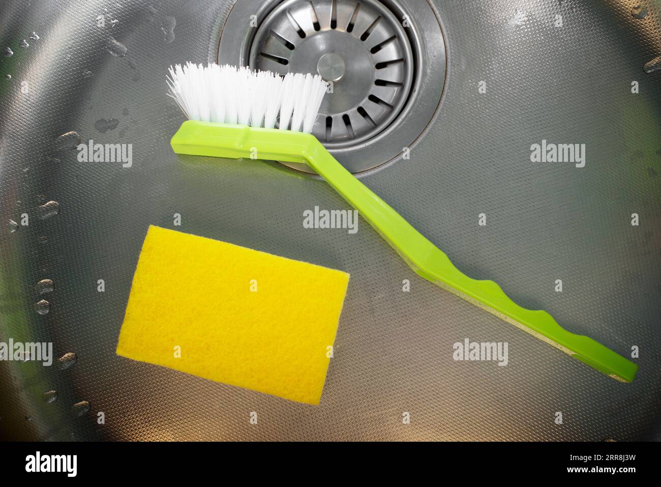 INOX Spülbecken aus Stahl mit Schwamm und Bürste, flach liegend Stockfoto