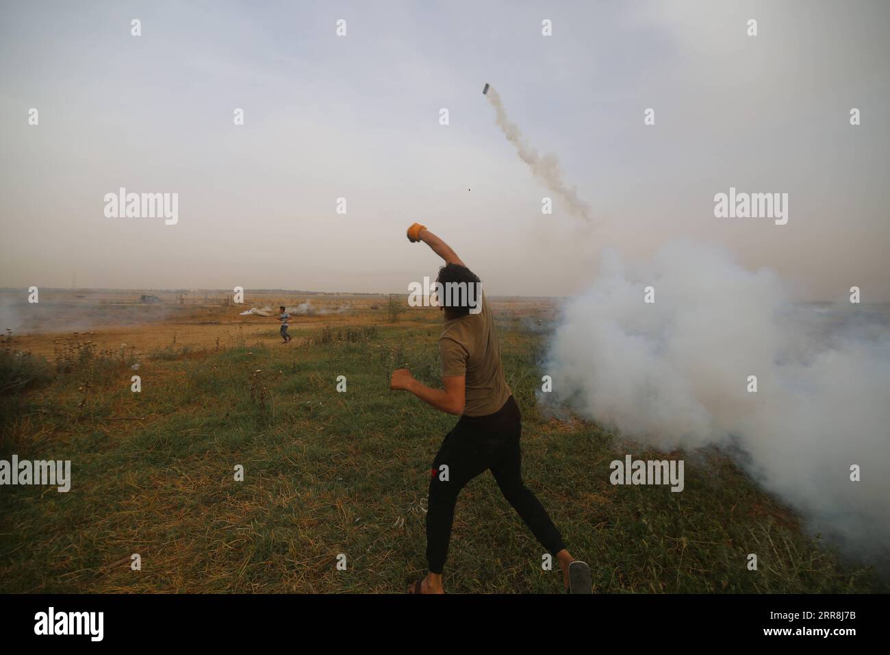 210509 -- GAZA, 9. Mai 2021 -- Ein palästinensischer Demonstrant wirft am 9. Mai 2021 einen Tränengaskanister zurück, während er gegen die Gewalt in Jerusalem an der Grenze zwischen Gaza und Israel östlich der Stadt Khan Younis im südlichen Gazastreifen protestiert. Etwa 290 Palästinenser wurden am Wochenende bei Zusammenstößen mit der israelischen Polizei auf dem Gelände der Al-Aqsa-Moschee und anderen Teilen Ost-Jerusalems verletzt. Foto von /Xinhua MIDEAST-GAZA-KHAN YOUNIS-PROTEST KhaledxOmar PUBLICATIONxNOTxINxCHN Stockfoto