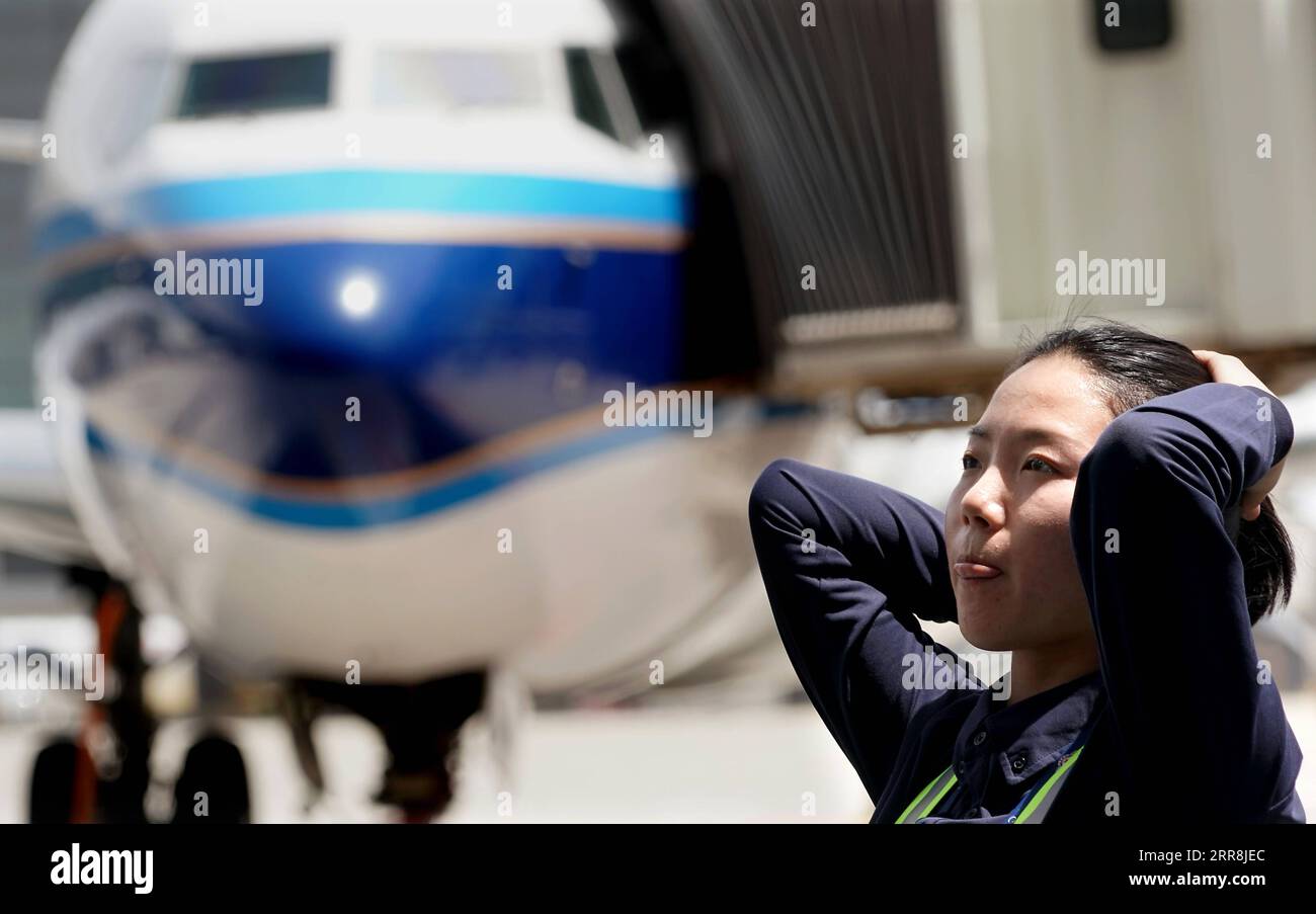 210510 -- ZHENGZHOU, 10. Mai 2021 -- Liu Qiqi arrangiert ihre Haare in einer Wartungsbasis der Henan-Niederlassung von China Southern Airlines in Zhengzhou, zentralchinesische Provinz Henan, 30. April 2021. Liu Qiqi ist ein 24-jähriger Mechaniker in der Henan-Niederlassung von China Southern Airlines. Liu Qiqi, die 2019 an der Civil Aviation University of China graduierte, ist ein Blickfang im Team, denn sie ist die einzige Mechanikerin unter den fast 200 Mitarbeitern in der Instandhaltung. Als sie in einer traditionell männlich dominierten Branche arbeitete, wurde Liu oft befragt, als sie in den Beruf eintrat. Die Arbeit erfordert eine harte Transplantation und ein Stockfoto