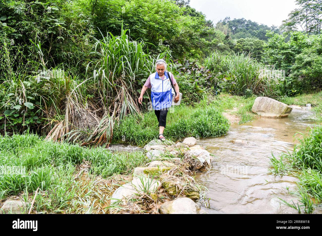 210512 -- NANNING, 12. Mai 2021 -- Wang Qiujiao ist auf dem Weg zur Arbeit im Dorf Zhumei, Stadt Hezhou in der südchinesischen autonomen Region Guangxi Zhuang, 11. Mai 2021. Wang Qiujiao, 74 Jahre alt und Mitglied der Kommunistischen Partei Chinas, ist seit 48 Jahren Dorfarzt im Dorf Zhumei. Das Dorf Zhumei, das sich in einer abgelegenen Berggegend befindet, war aufgrund des schlechten Transports von der Außenwelt isoliert. Die Ärzte im Dorf waren damals knapp und die Menschen mussten in die Nachbarstadt gehen, um einen Arzt zu besuchen. Die meisten Dorfbewohner entschieden sich, keinen Arzt aufzusuchen, bis ihr Unwohlsein zerbrach Stockfoto