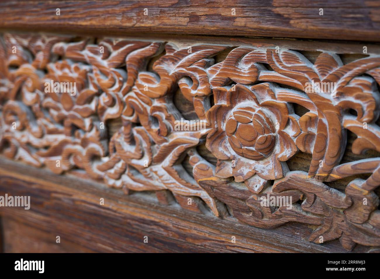 Muster, die auf den Holztüren eines alten koreanischen Tempels gemeißelt wurden Stockfoto