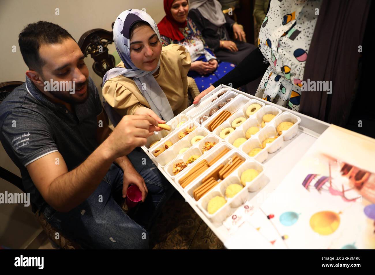 210513 -- KAIRO, 13. Mai 2021 -- Mitglieder einer ägyptischen Familie genießen Süßigkeiten, während sie die Eid al-Fitr zu Hause inmitten der COVID-19-Pandemie in Kairo, Ägypten, 13. Mai 2021 feiern. Viele Ägypter beschließen, die Eid al-Fitr zu Hause zu feiern, da die COVID-19-Fälle im Land weiter zunahmen. ÄGYPTEN-KAIRO-EID AL-FITR-CELEBRATION AHMEDXGOMAA PUBLICATIONXNOTXINXCHN Stockfoto