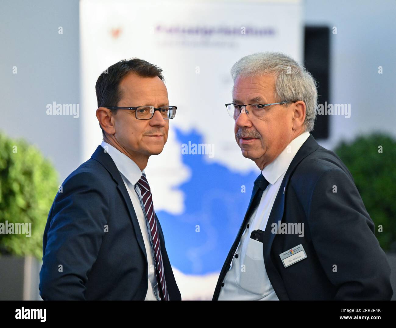 Cottbus, Deutschland. September 2023. Jörg Müller (l), Leiter des brandenburgischen Verfassungsschutzamtes, und Harald Altekrüger (CDU), Landrat des Landkreises Spree-Neiße, nehmen an dem Symposium zum Hassverbrechen im Messegelände Cottbus Teil. Auf dem öffentlichen Symposium sprechen Teilnehmer des Verfassungsschutzamtes, der Polizei, des LKA und anderer Behörden und Organisationen über Hassverbrechen. Quelle: Patrick Pleul/dpa/Alamy Live News Stockfoto