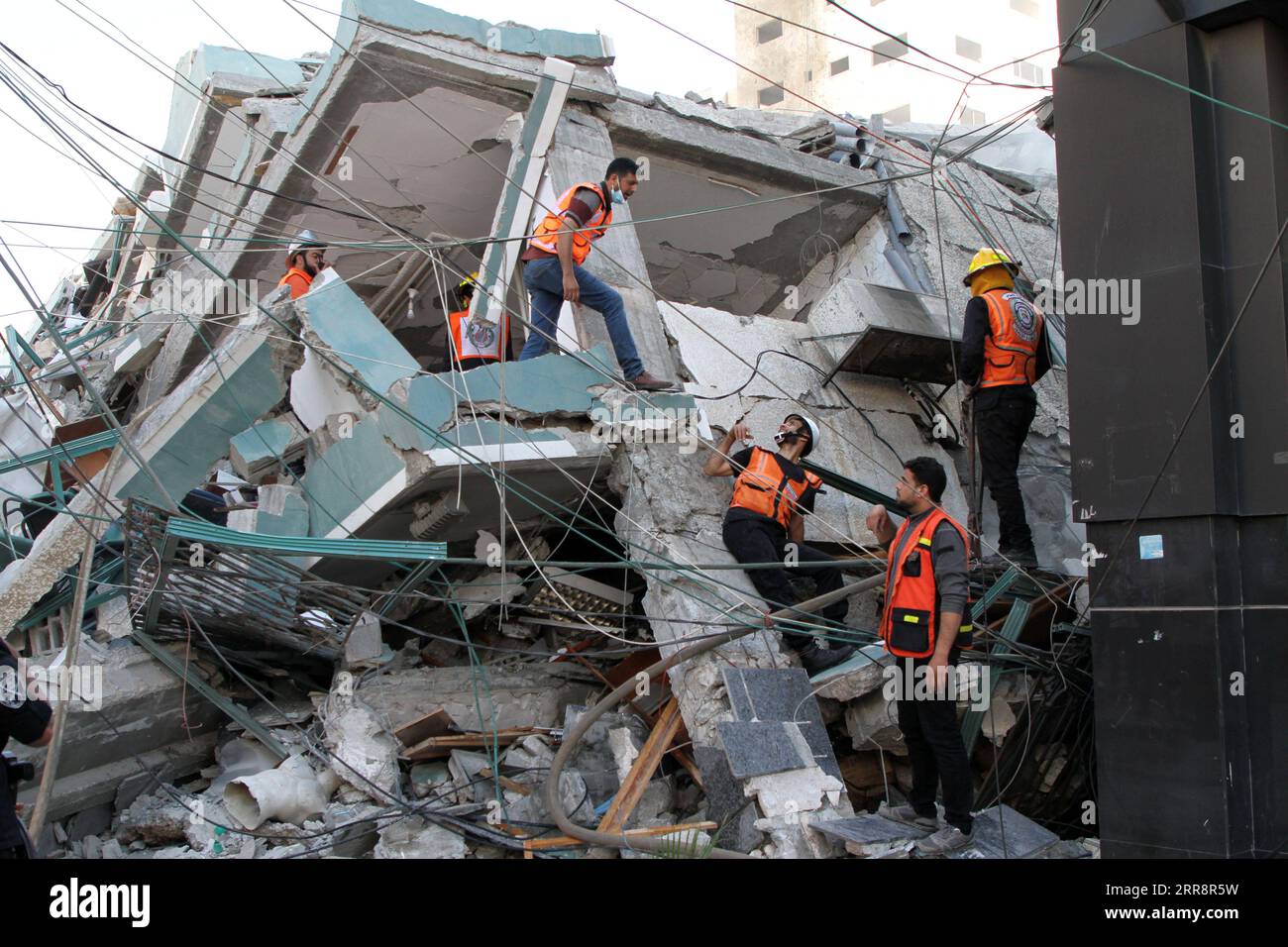 210516 -- GAZA CITY, 16. Mai 2021 -- Retter überprüfen Trümmer des Jala Tower, in dem sich Büros von Al-Jazeera TV und Associated Press sowie Wohnwohnungen befanden, nachdem er am 15. Mai 2021 von einem israelischen Luftangriff in Gaza City getroffen wurde. Israel sagte am Samstag, dass es das Hochhaus in Gaza City, in dem Büros internationaler Medien untergebracht sind, getroffen habe, weil es Vermögenswerte des Hamas-Geheimdienstes enthielt. Foto von /Xinhua MIDEAST-GAZA CITY-AIRSTRIKE-JALA TOWER RizekxAbdeljawad PUBLICATIONxNOTxINxCHN Stockfoto