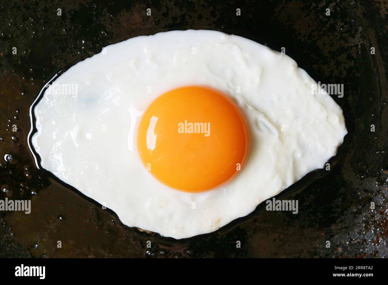 Draufsicht auf ein sonniges Ei, das in einer Pfanne gebraten wird Stockfoto