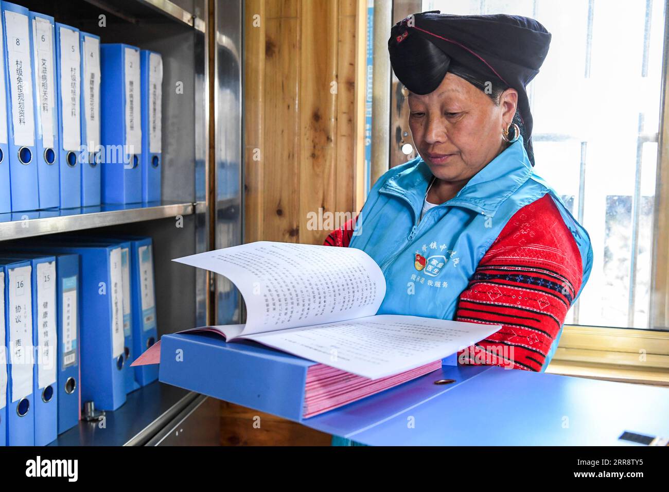 210518 -- NANNING, 18. Mai 2021 -- Pan Jiping arrangiert die Gesundheitsakten der Dorfbewohner im Dorf Xiaozhai der Gemeinde Longji, Kreis Longsheng, südchinesische autonome Region Guangxi Zhuang, 18. Mai 2021. In Xiaozhai, einem Dorf am Fuße des Fupingbao-Berges auf über 1.900 Metern über dem Meeresspiegel, ist Pan Jiping seit über 30 Jahren Landarzt hier. Pan, 57, ist einer der Hongyao, ein Zweig der Yao-ethnischen Gruppe. Im Jahr 1988 ging Pan zur Gesundheitsschule des Bezirks, um Medizin zu studieren, um die Schwierigkeiten der Dorfbewohner zu lösen, einen Arzt zu besuchen. 1990, nach Abschluss ihres Studiums, wurde Pa Stockfoto