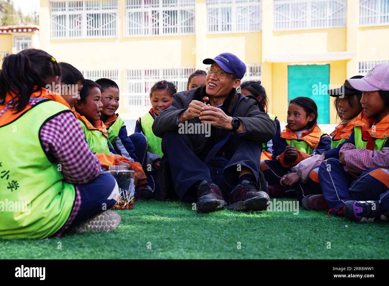 210519 -- PEKING, 19. Mai 2021 -- Li Chunmin C spricht mit Schülern an der Grundschule der Gemeinde Yiri in der Gemeinde Yiri, Riwoqe County von Qamdo, südwestchinesische Autonome Region Tibet, 1. Mai 2021. Im China Photo Archive von Xinhua befindet sich ein Foto einer Zahlungsanweisung, die vor 20 Jahren von einem Xinhua-Reporter aufgenommen wurde - die erste Überweisung, die vom Hauptquartier für den Bau der Qinghai-Tibet-Eisenbahn erhalten wurde. Die Zahlungsanweisung wurde nicht unterzeichnet, da der Absender Cadre, der 1979 zur Unterstützung Tibets geschickt wurde, darauf setzte. Zwanzig Jahre später fanden Xinhua-Reporter Li Chunmin, den Besitzer der Zahlungsanweisung. Li, 70, arbeitete in Tianj Stockfoto