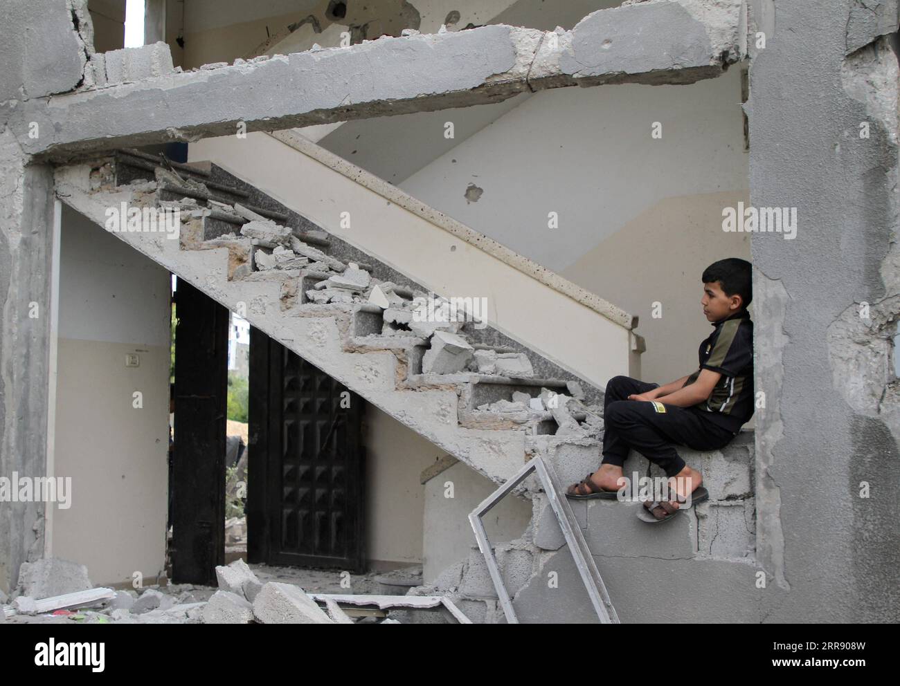 210521 -- GAZA, 21. Mai 2021 -- Ein palästinensisches Kind sitzt in seinem Haus, das nach dem Waffenstillstand zwischen Israel und der Hamas am 21. Mai 2021 in der Stadt Beit Lahia im nördlichen Gazastreifen zerstört wurde. Ein von Ägypten vermitteltes Waffenstillstandsabkommen zwischen Israel und der Hamas, das den Gazastreifen regelt, trat am frühen Freitag in Kraft und beendete das 11-tägige Blutvergießen. Die Kämpfe zwischen Israel und den von der Hamas geführten militanten Gruppen im Gazastreifen haben mehr als 100 Menschen getötet und Zehntausende von Menschen vertrieben. Foto von /Xinhua MIDEAST-GAZA-WAFFENSTILLSTAND RizekxAbdeljawad PUBLICATIONxNOTx Stockfoto