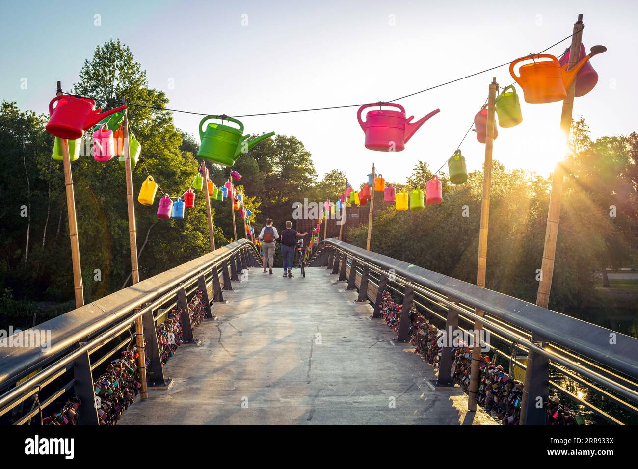 Bunte Fußgängerbrücke über den Trave River mit warmem Licht bei Sonnenuntergang. Foto aufgenommen am 6. Juni 2023 in Lübeck oder der Hansestadt Luebe Stockfoto