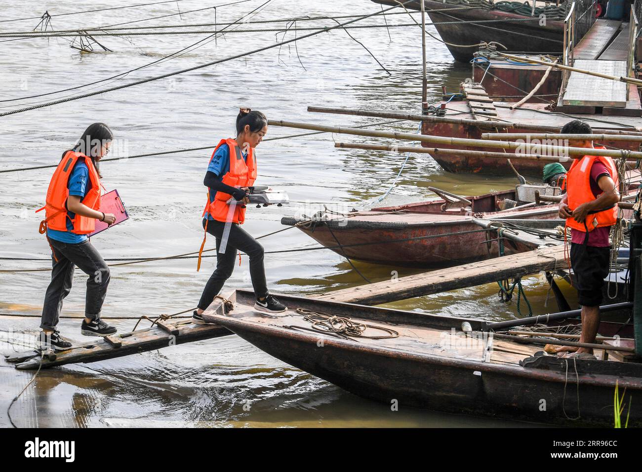 210530 -- GUIPING, 30. Mai 2021 -- Yuan Ting 2nd L und seine Kollegen gehen an Bord eines Fischerbootes, um im Wasserschutzgebiet Datengxia Gorge in Guiping, der südchinesischen autonomen Region Guangxi Zhuang, am 29. Mai 2021 Fischereiressourcen zu erforschen. Dr. Yuan Ting, ein Experte für ökosystembasierte Fischerei und die Züchtung seltener Fischarten, kam 2020 mit einem Forscherteam zur Dateng Gorge Water Conservancy. Der Schwerpunkt ihrer Forschung liegt auf der Rettung, dem Schutz und der Züchtung seltener Fischarten, die im Einzugsgebiet des Pearl River beheimatet sind. Am 28. Mai veröffentlichte Yuans Team 100.000 Fischbrut, die sie in einem Jahr gezüchtet haben Stockfoto