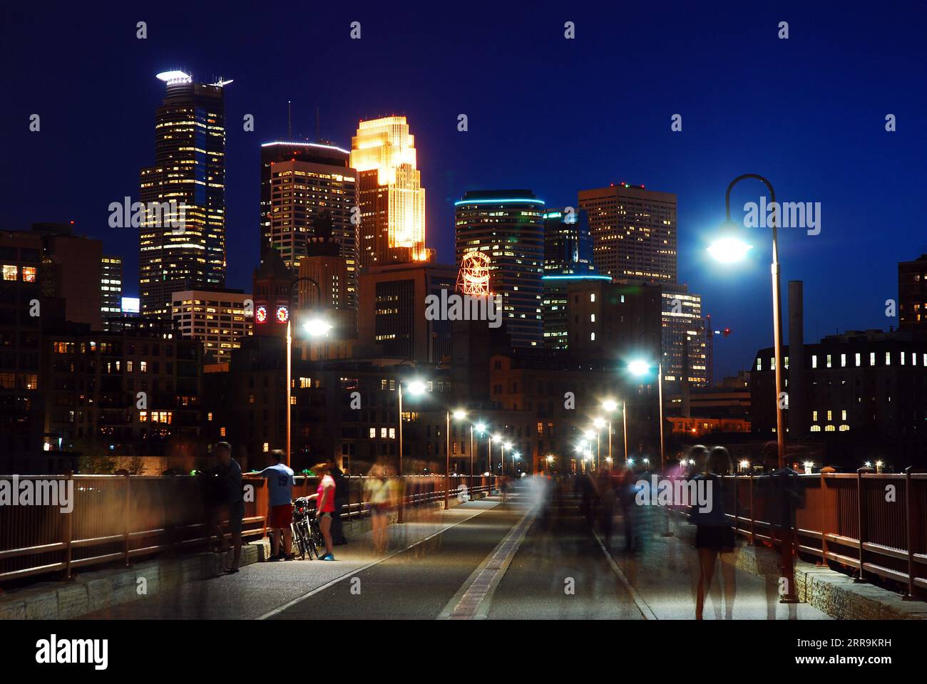 Ein nächtlicher Spaziergang entlang der Stone Arch Bridge, der zur Skyline von Minneapolis führt Stockfoto