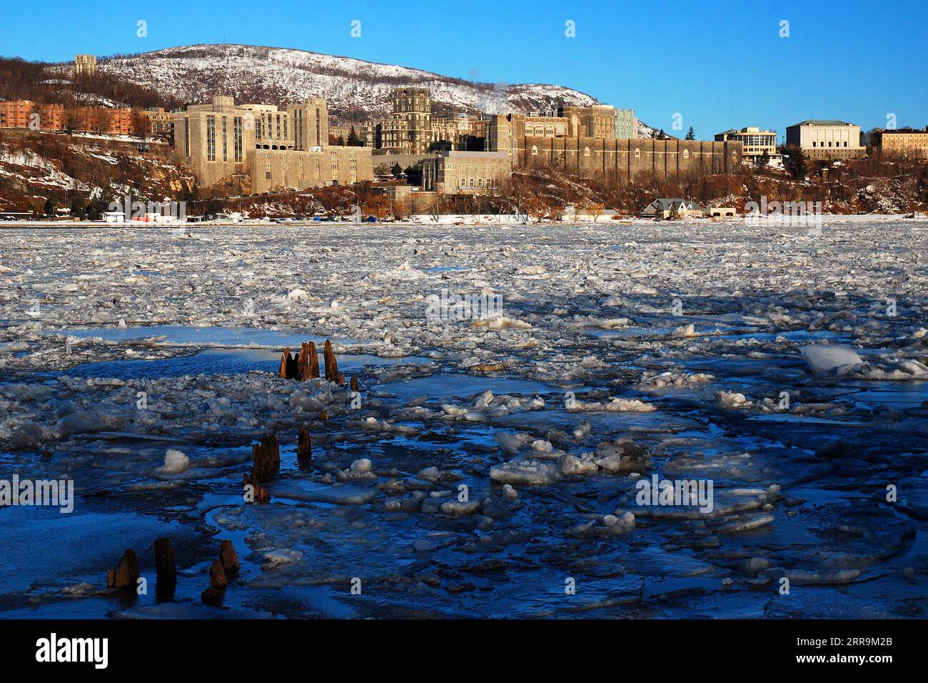 Die United States Military Academy (USMA) befindet sich an einem kalten Wintertag über einem gefrorenen und eisigen Hudson River Stockfoto