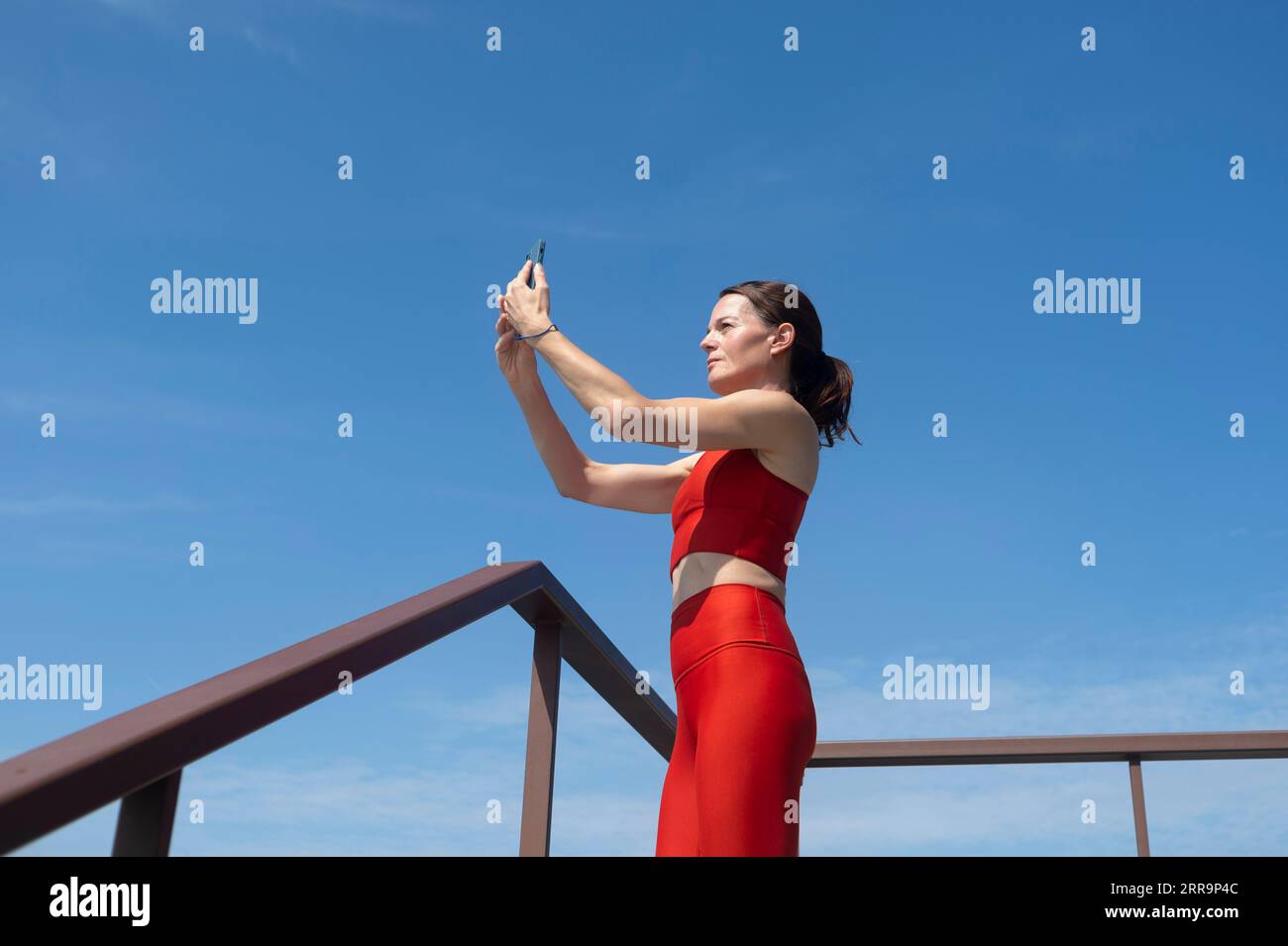 Sportliche Frau, die ein Selfie auf ihrem Handy macht, Outdoor-Fitnesskonzept. Stockfoto